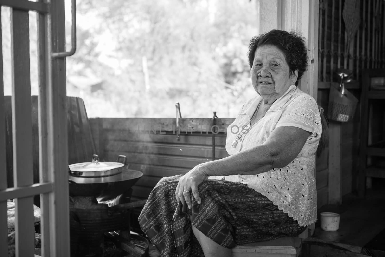 Black and white image of Senior asian woman cooking in kitchen