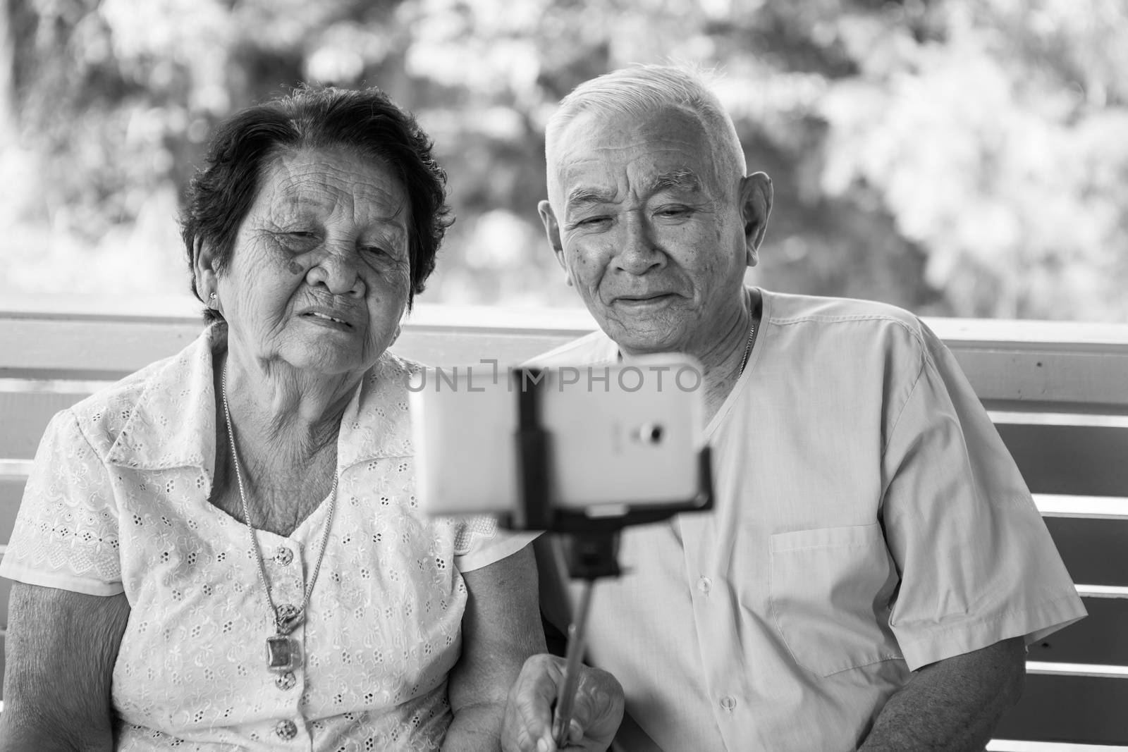 Black and white image of Happy senior couple posing for a selfie at home