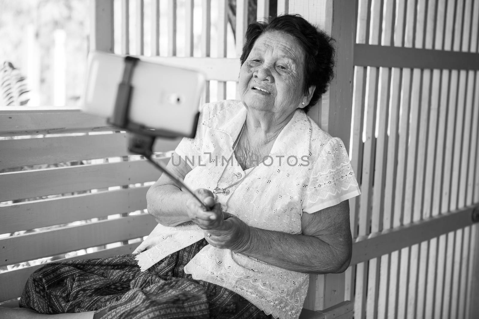 Black and white image of Happy senior woman posing for a selfie at home