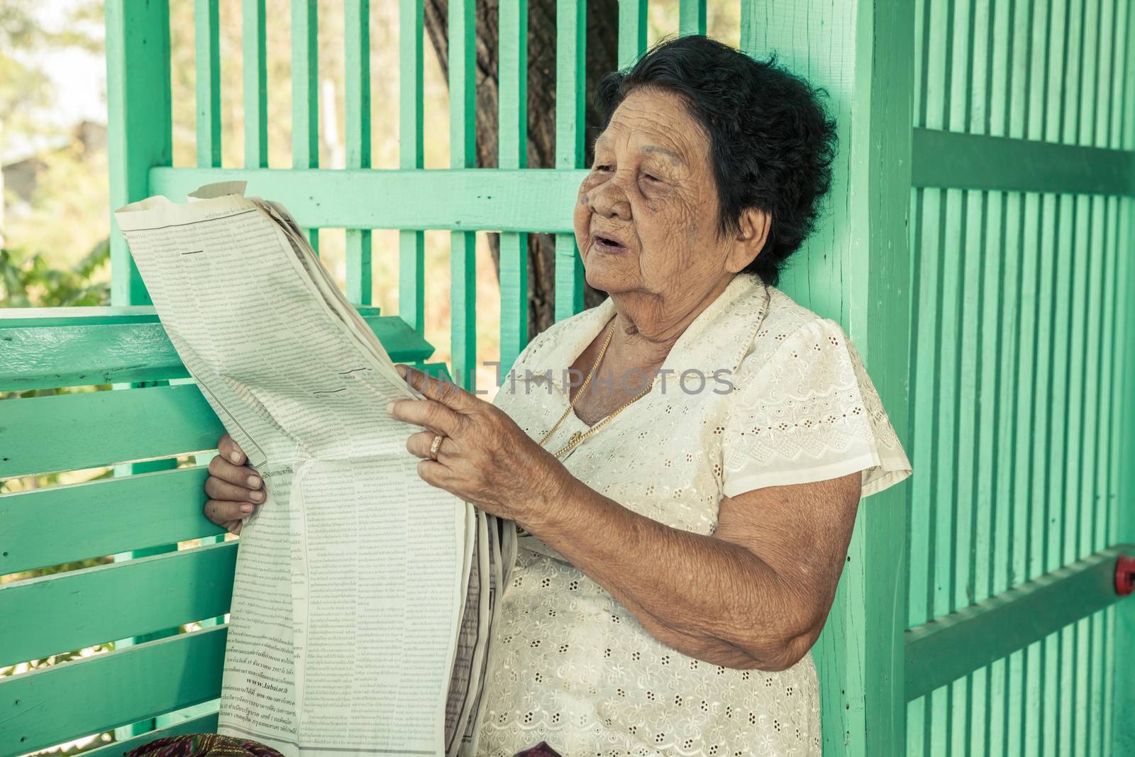 Senior asian woman Relaxing With Newspaper