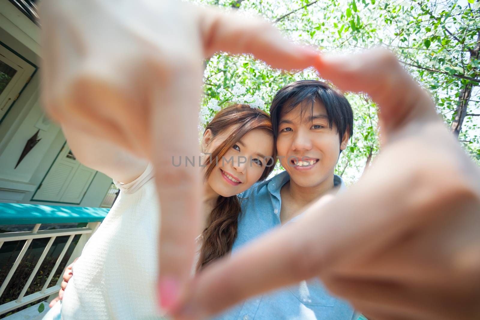 Loving asian couple under tree in the park