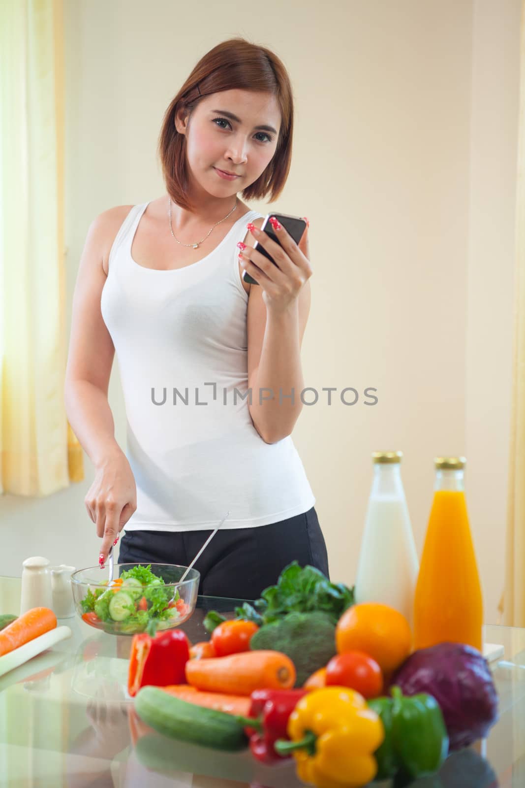 Young woman Following Recipe On mobile phone by witthaya
