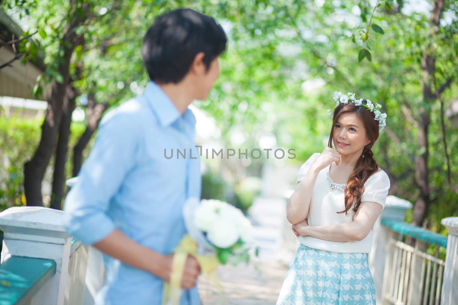 Man ready to give flowers to girlfriend in the park