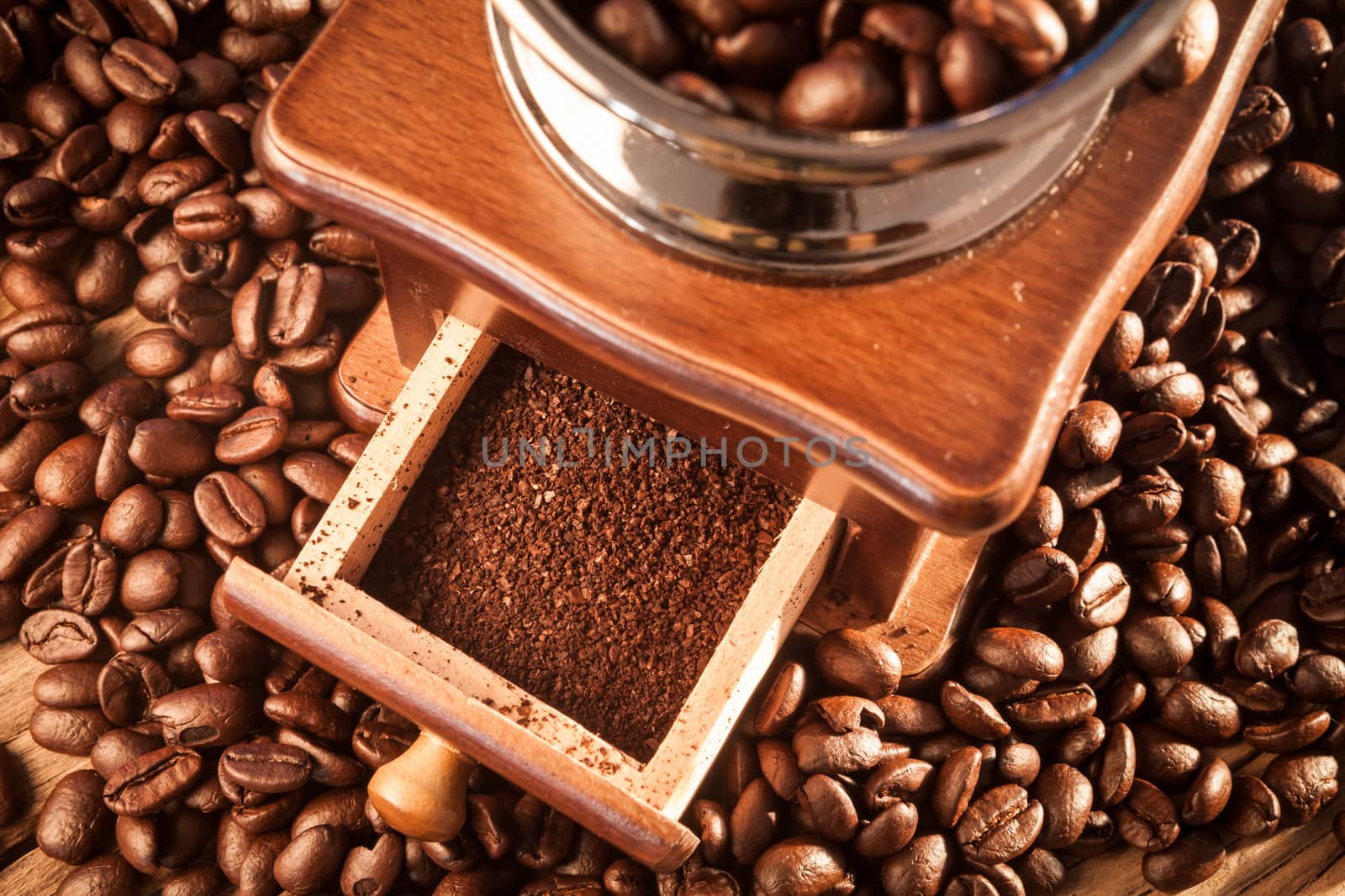 Vintage manual coffee grinder with coffee beans on wood table