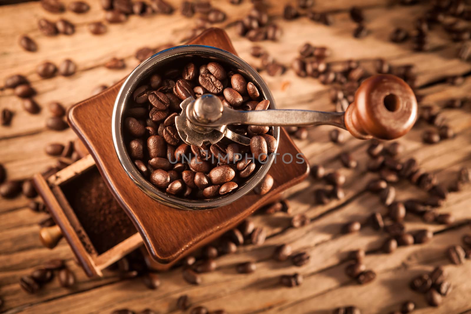 Vintage manual coffee grinder with coffee beans on wood table