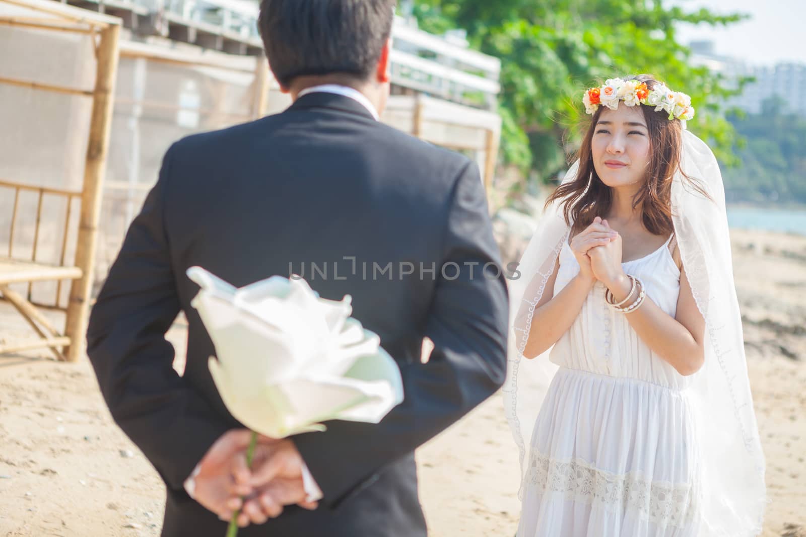 Beautiful asian couple on the beach in wedding dress