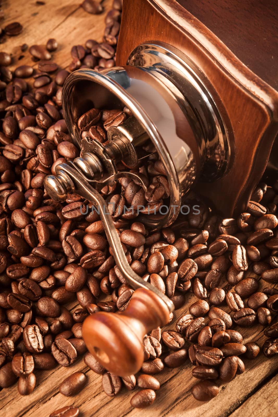 Vintage manual coffee grinder with coffee beans on wood table