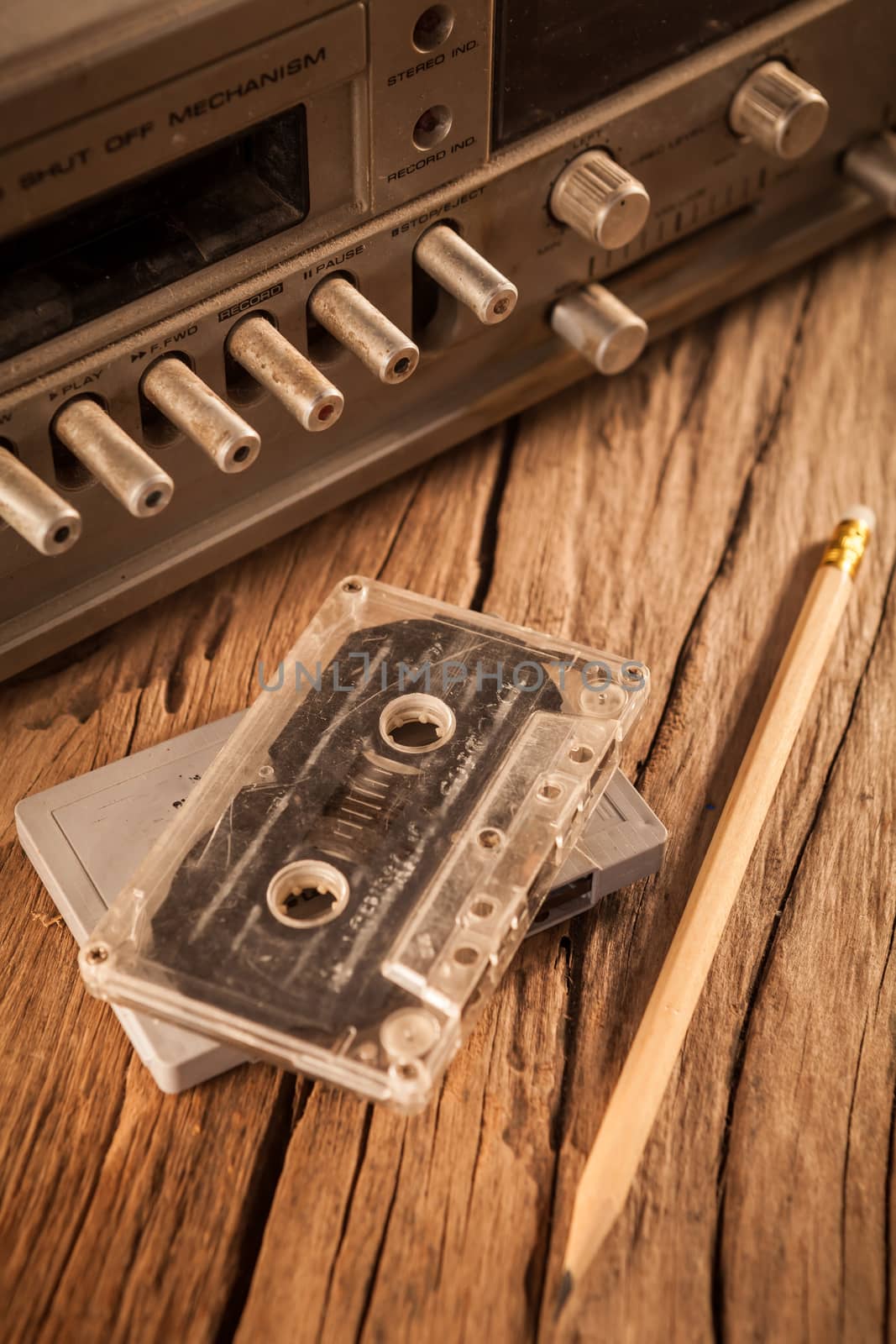 Old cassette tapes and cassette player on wooden surface