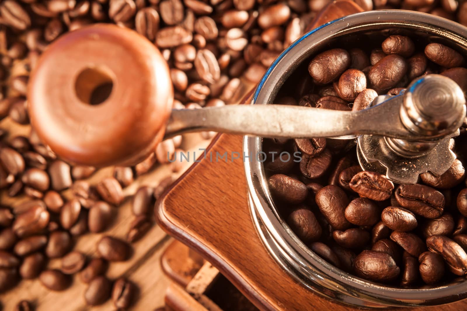 Vintage manual coffee grinder with coffee beans on wood table