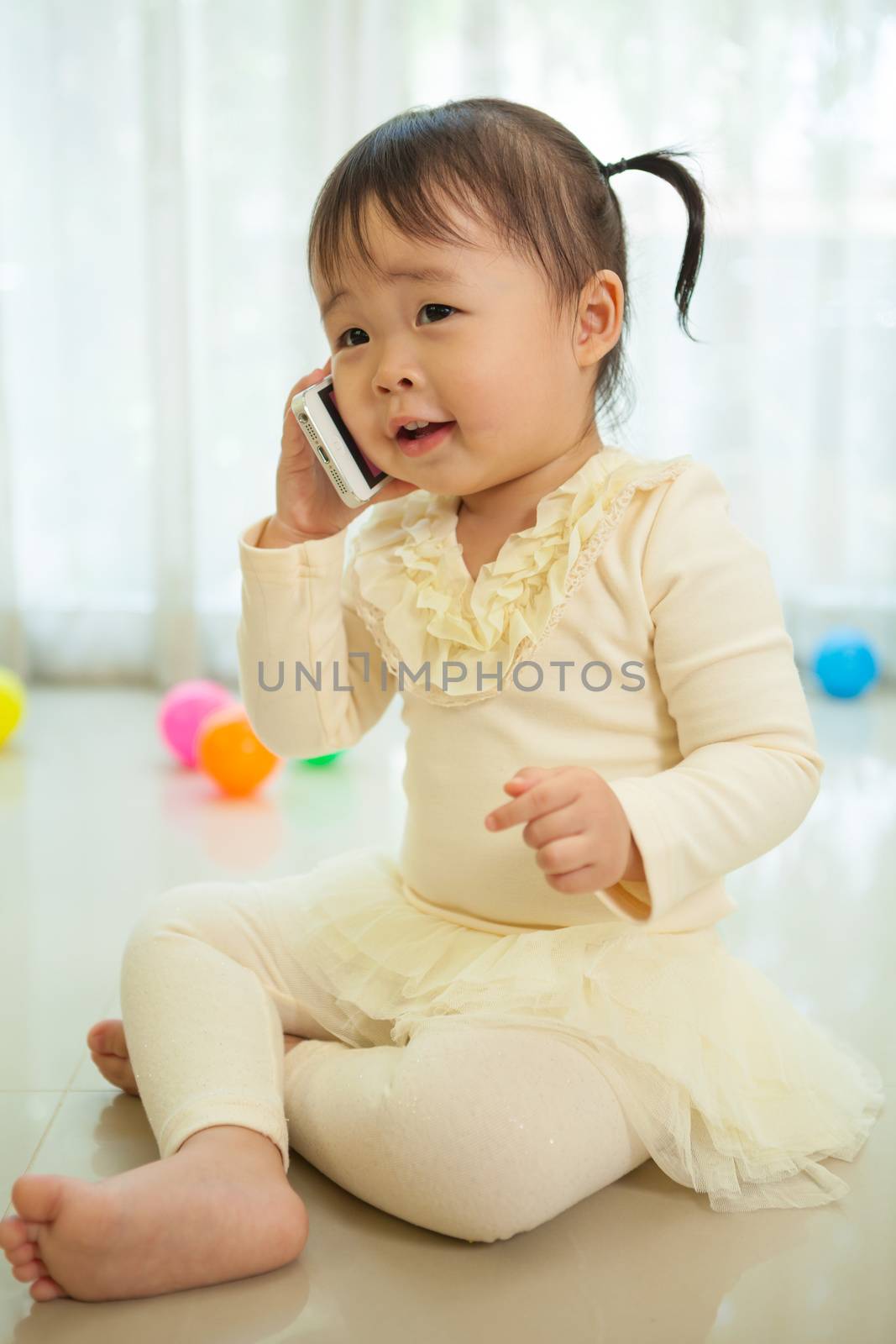 Little girl talking on mobile phone by witthaya