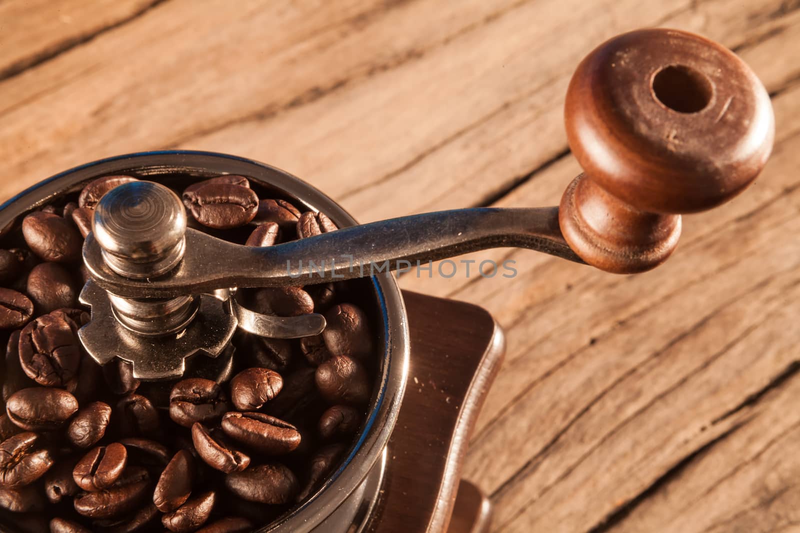 Vintage manual coffee grinder with coffee beans on wood table