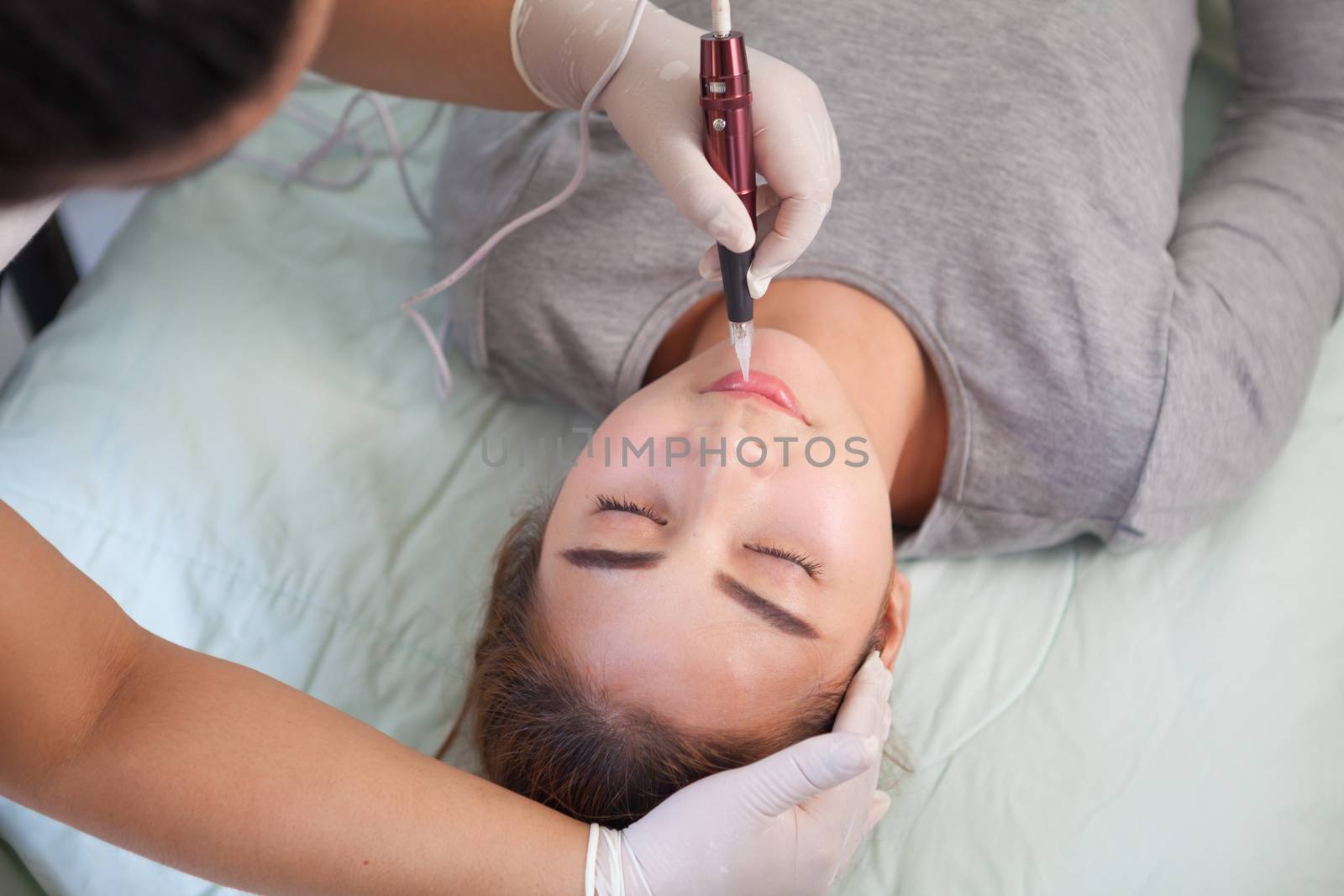 Professional permanent makeup applying on eyebrow