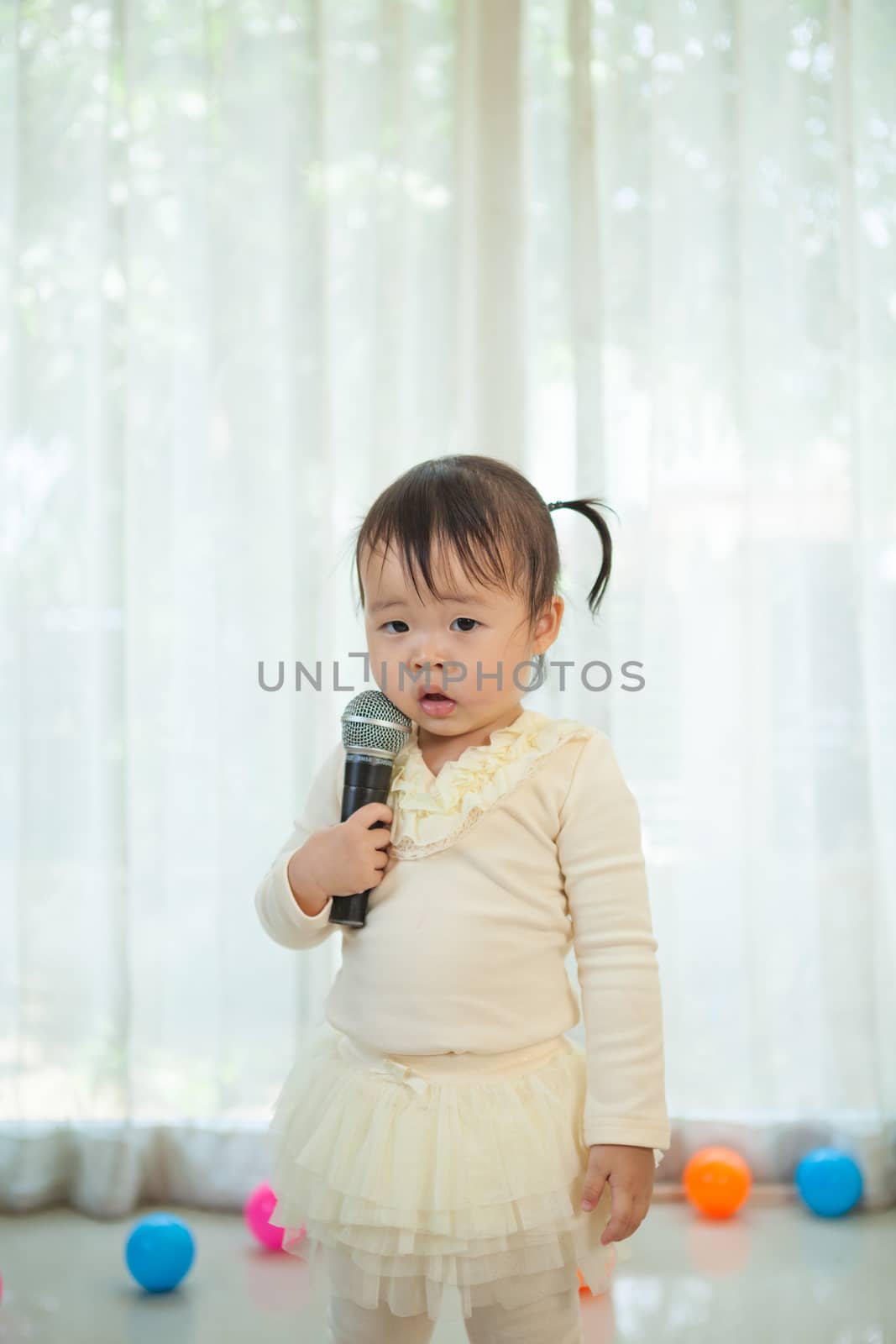 little asian girl with microphone by witthaya