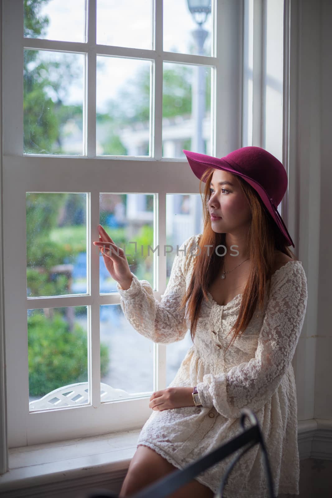 Sad asian vintage woman on the window looking out the window