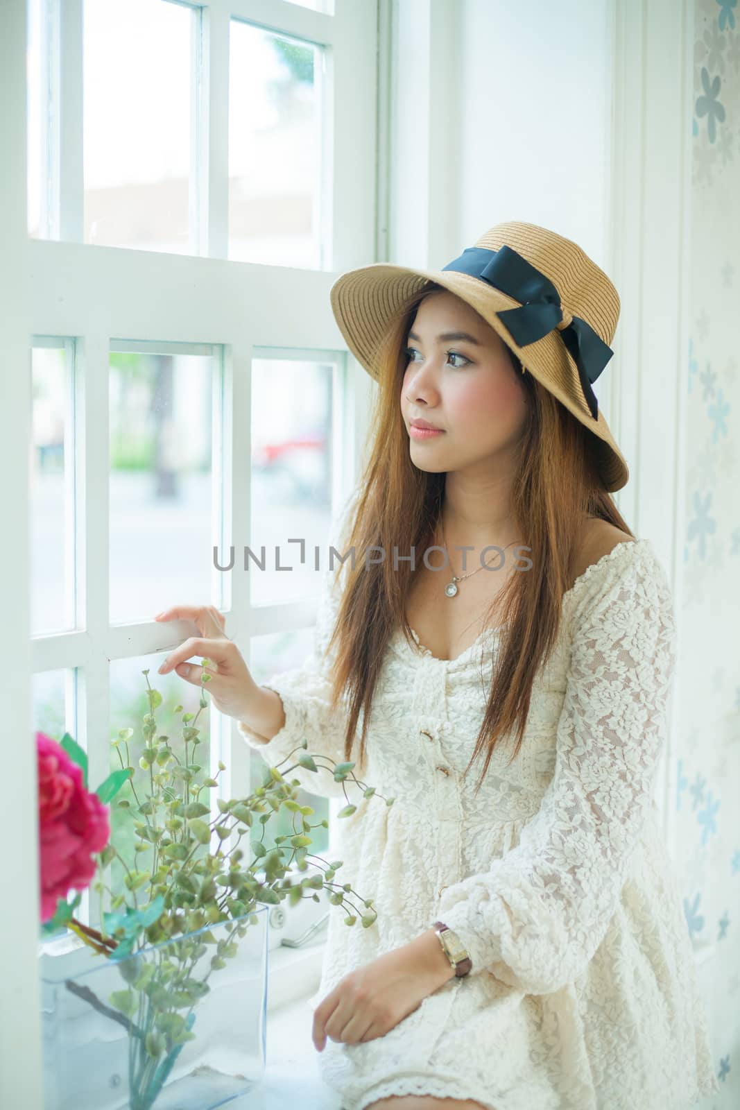 Sad asian vintage woman on the window by witthaya