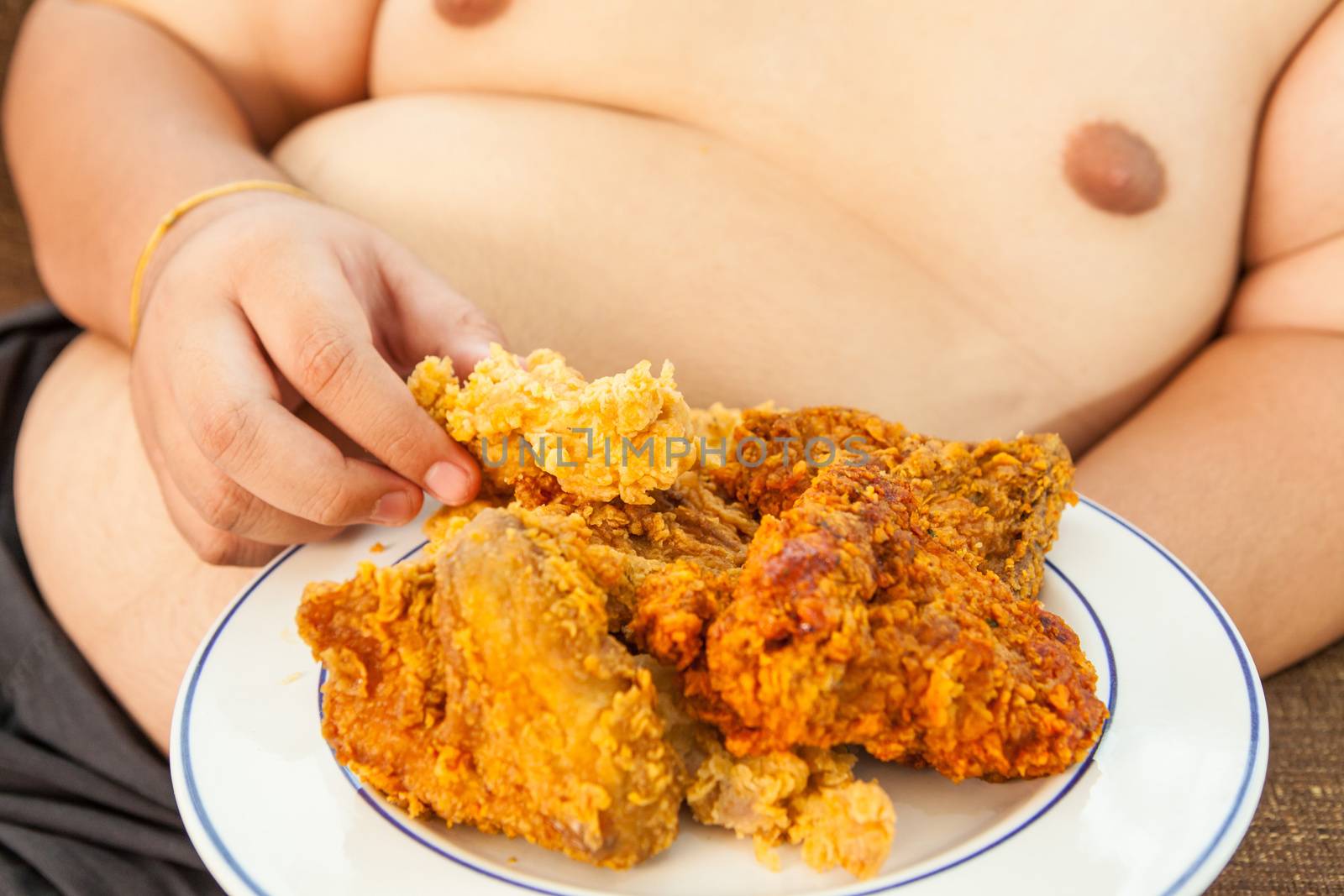 Asian fat man eating fried chicken