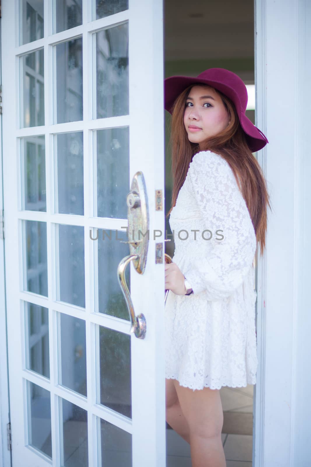 Sad asian vintage woman looking out the door
