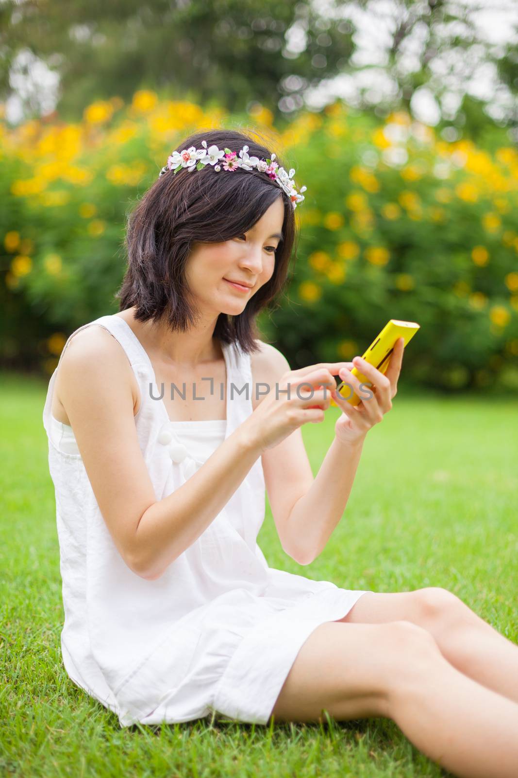 Asian woman using mobile smart phone in the park