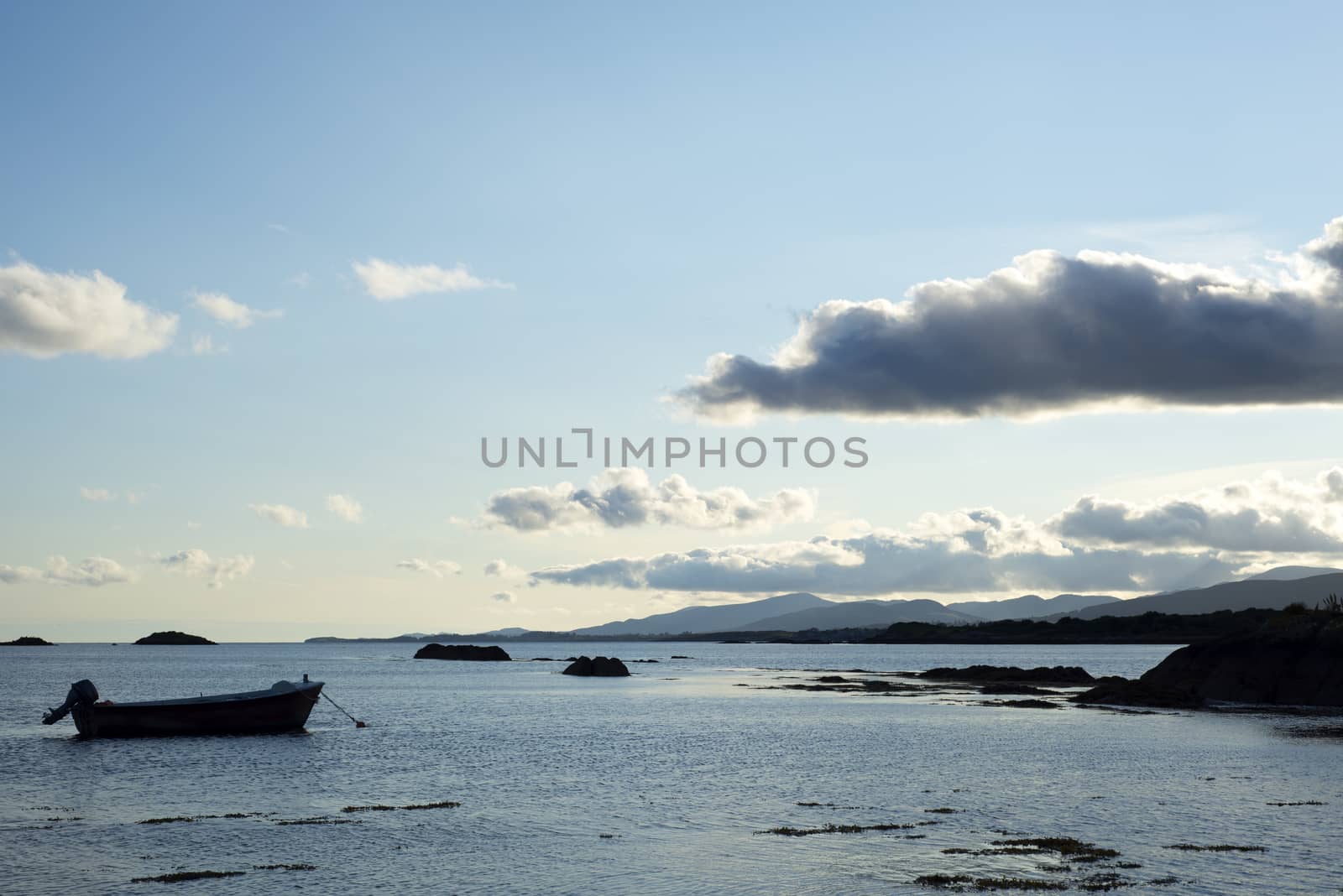 boat in a quiet bay near kenmare on the wild atlantic way ireland at blue sunset