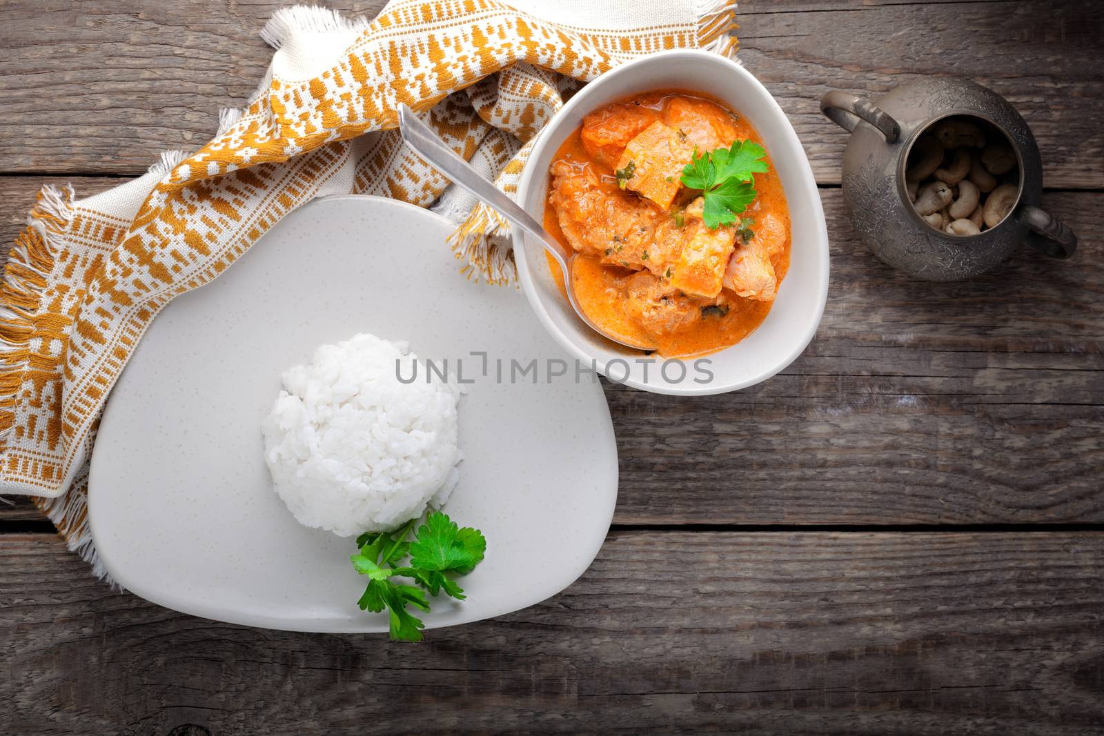 Chicken curry and rice served on a wooden surface