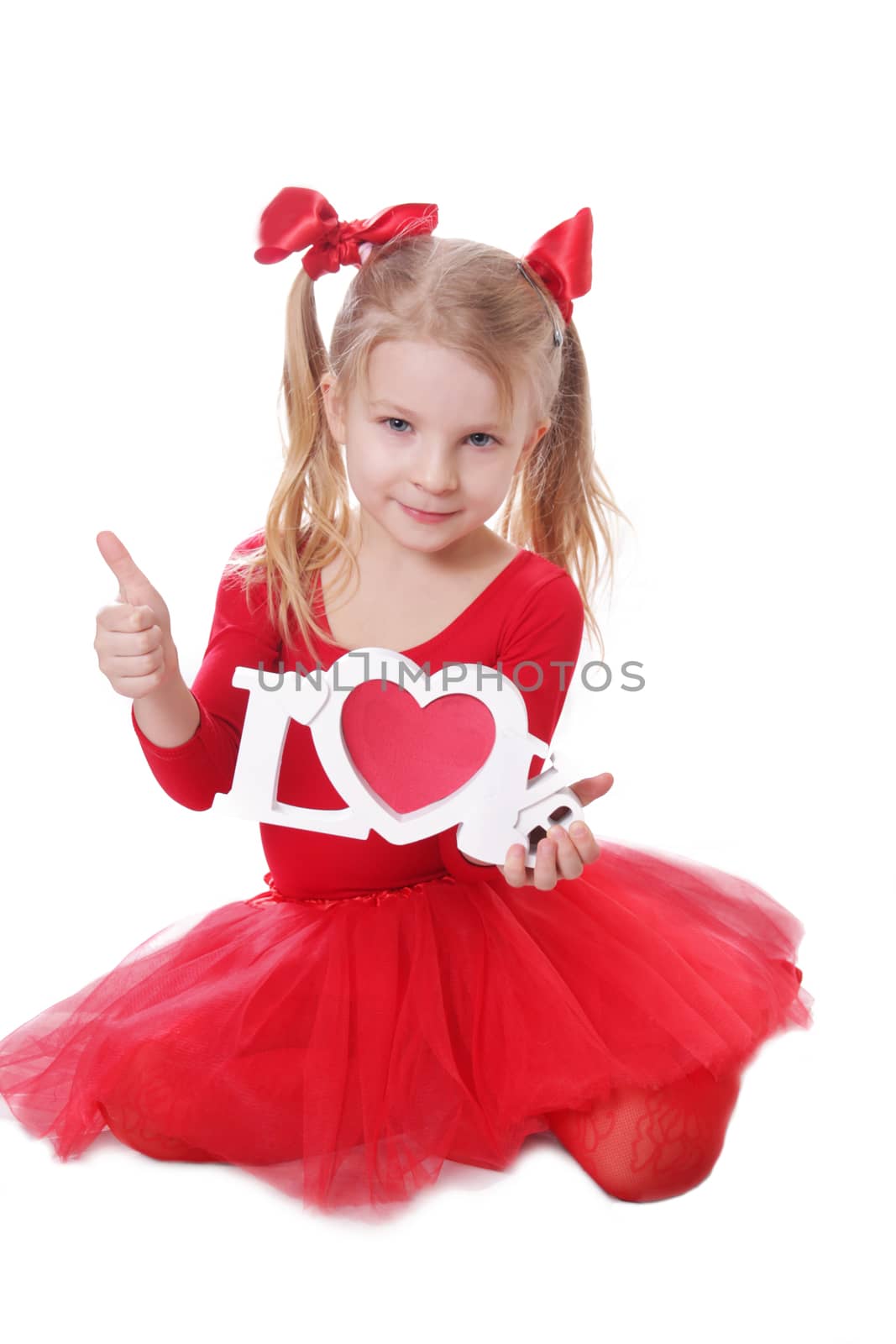 Cute little girl in red holding love words  on white