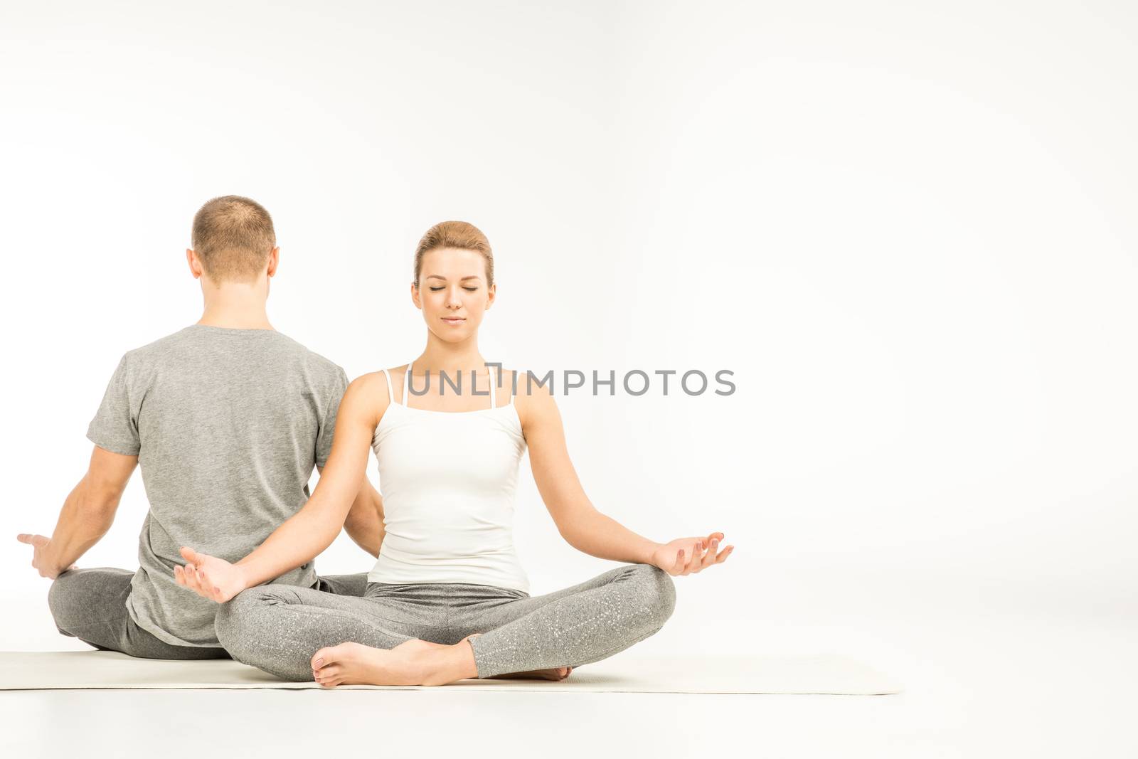 Couple sitting in lotus position   by LightFieldStudios