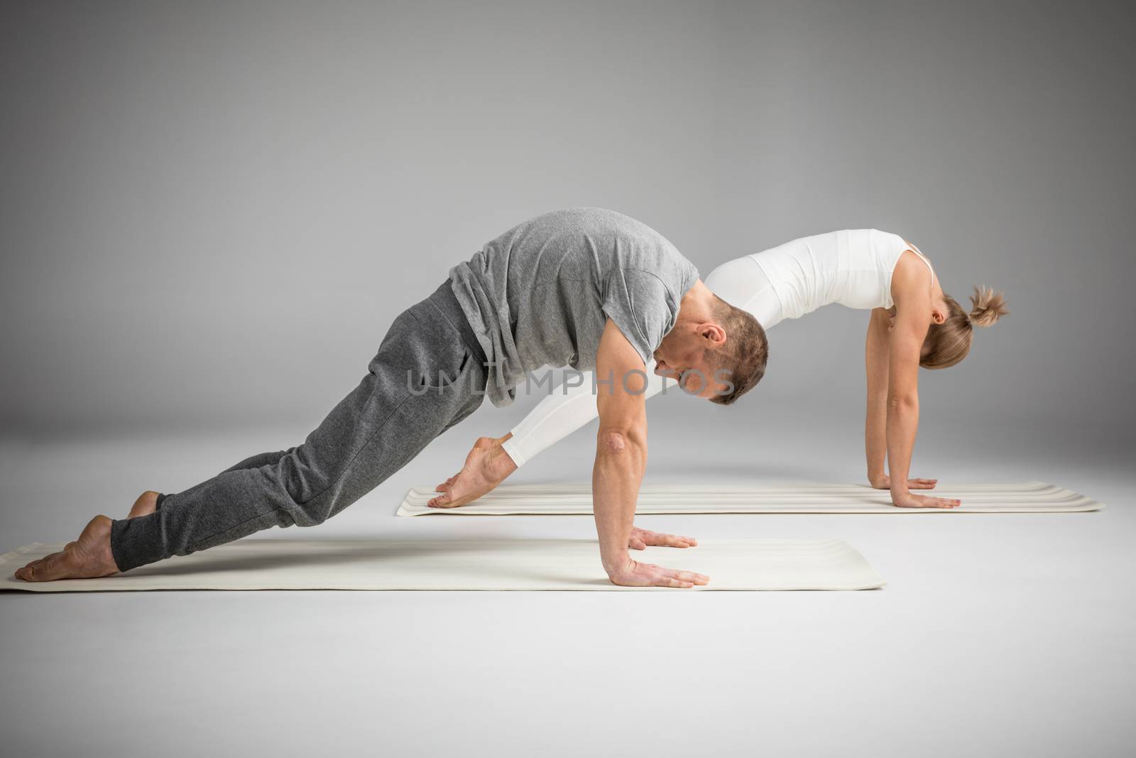 Couple practicing yoga by LightFieldStudios