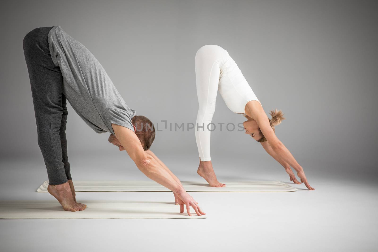 Couple practicing yoga by LightFieldStudios
