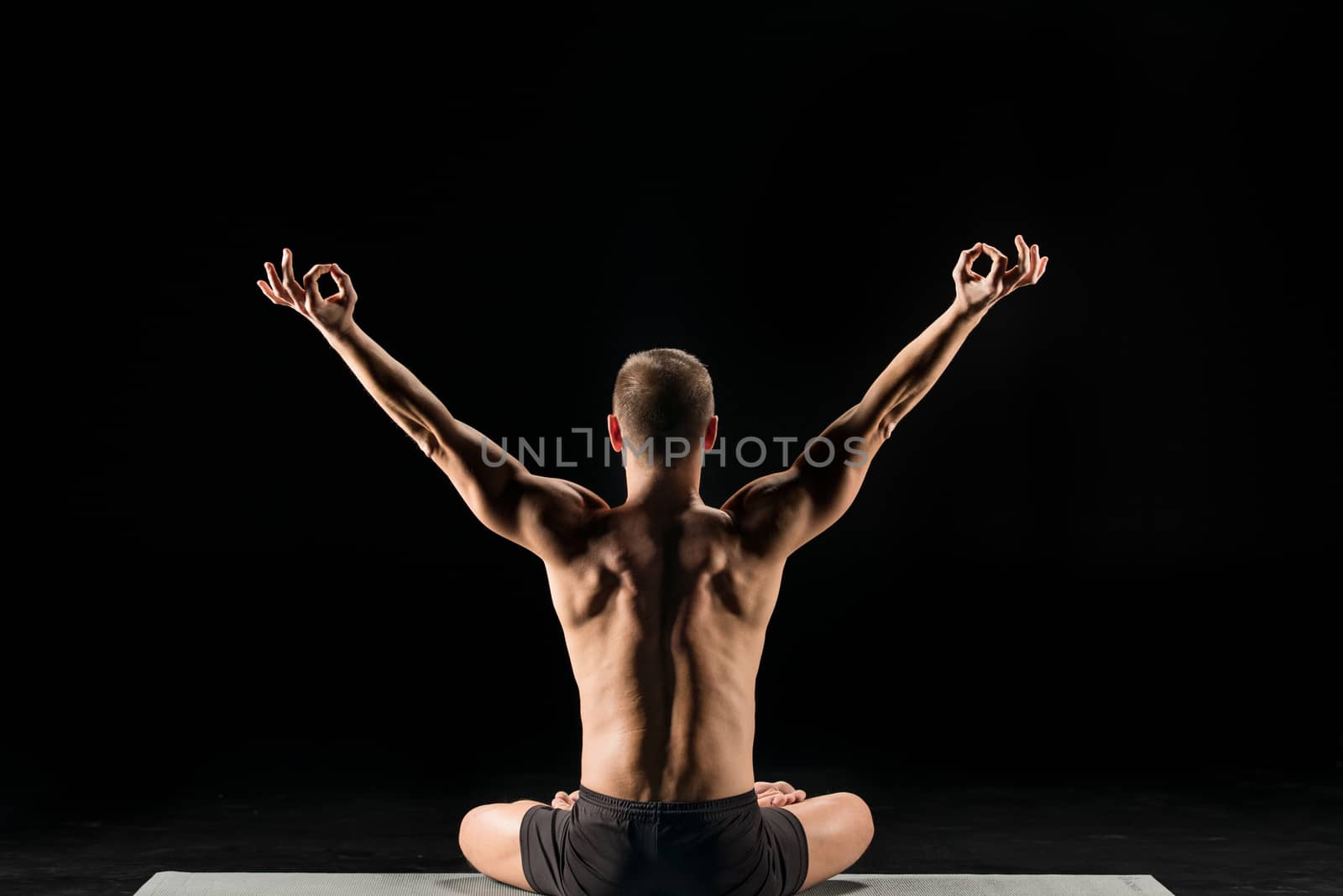 Man sitting and meditating by LightFieldStudios
