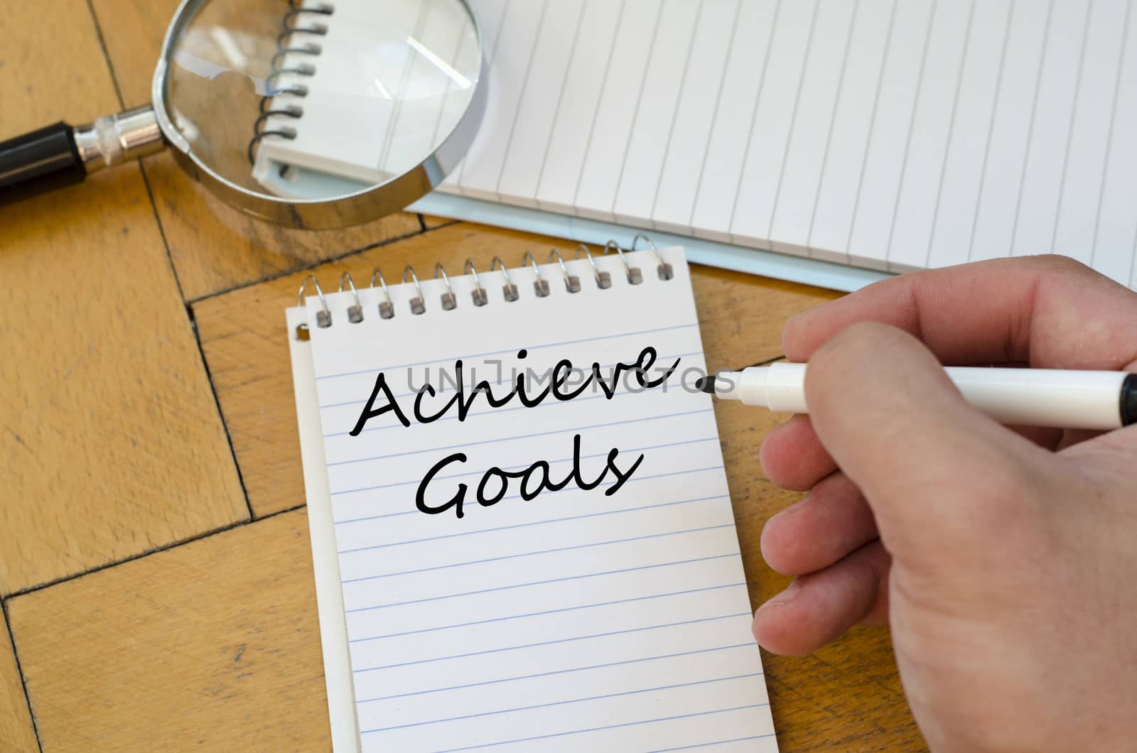 Achieve goals text concept write on notebook