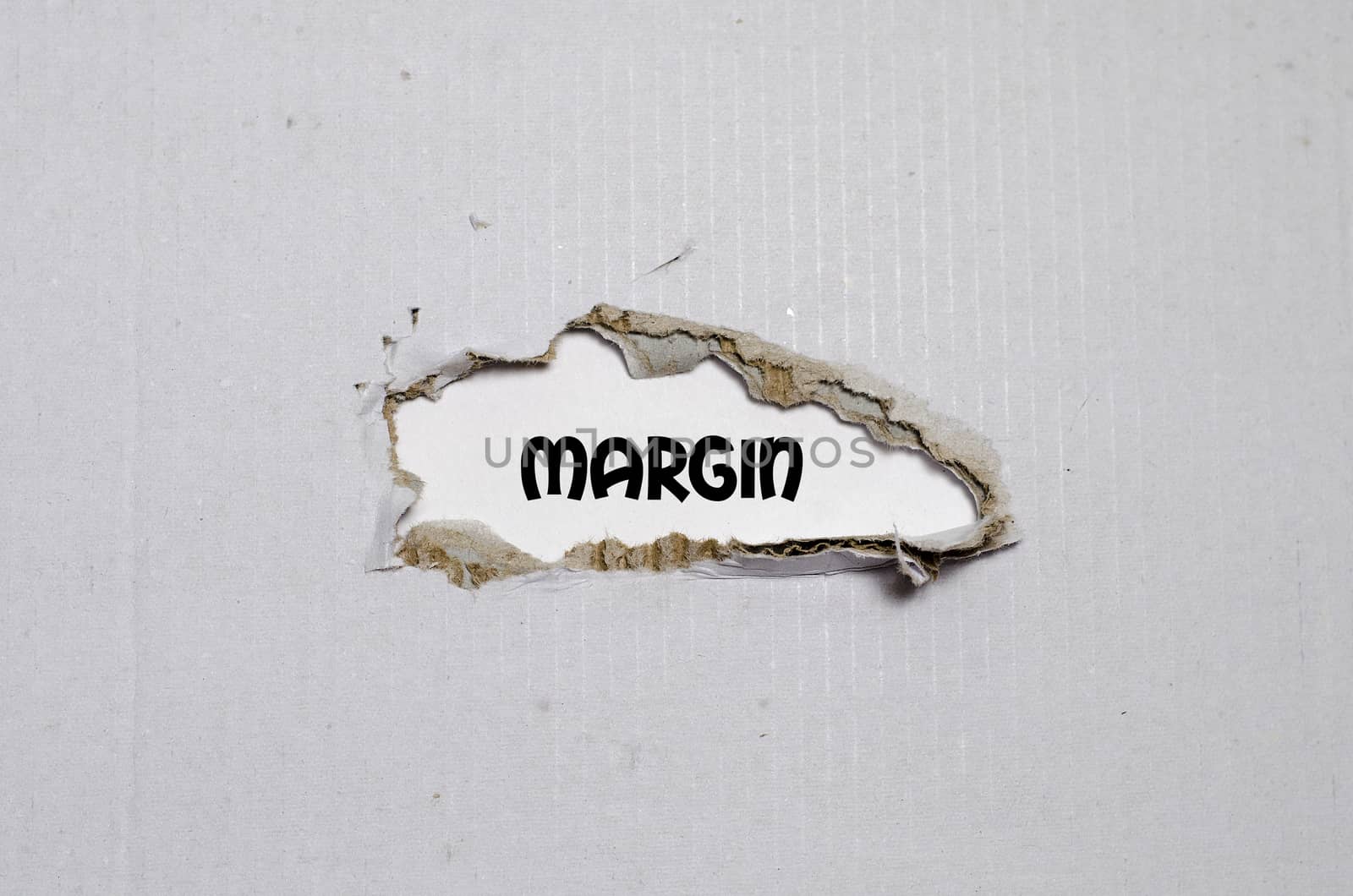 The word margin appearing behind torn paper