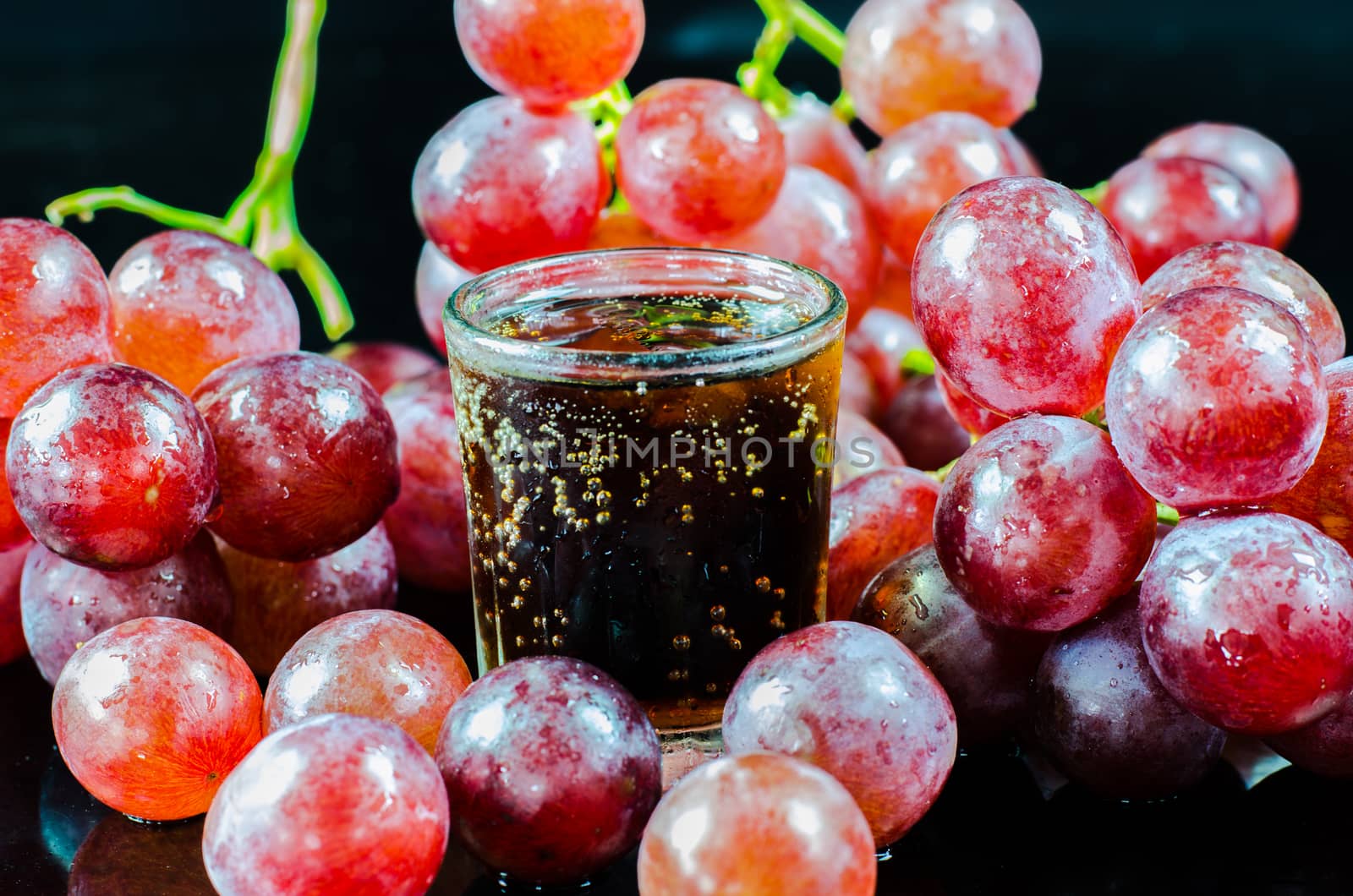 glass of wine red grape isolated on black background