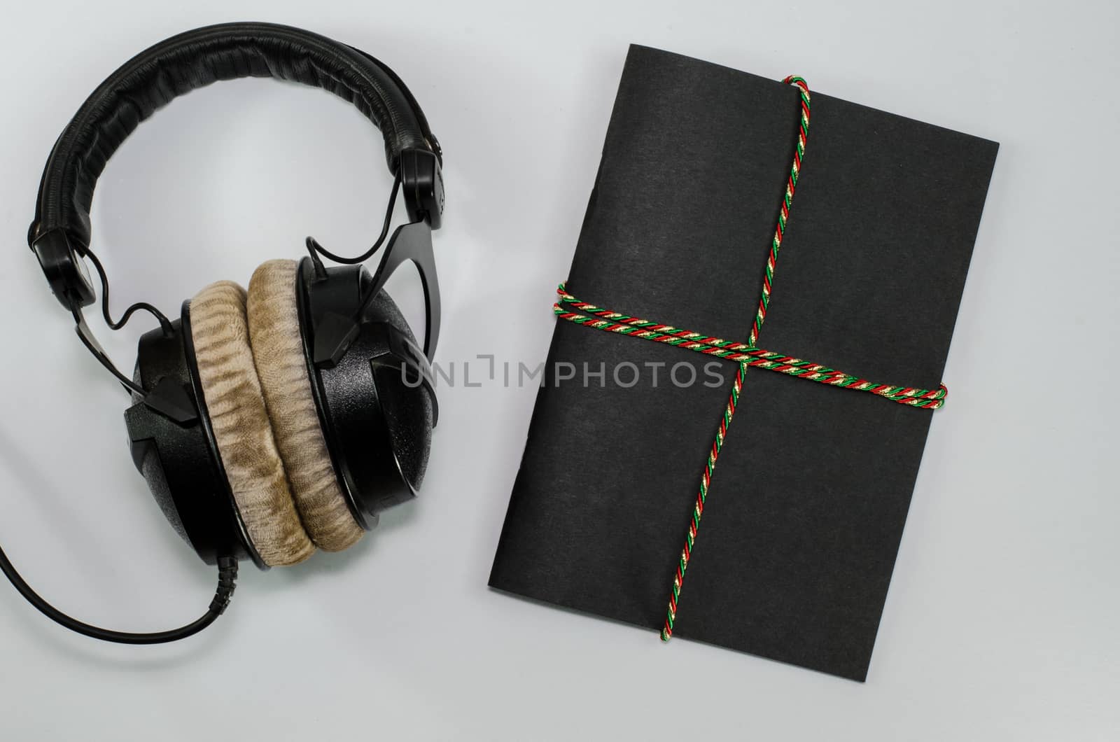 Headphone and notebook front cover on white background by metal22