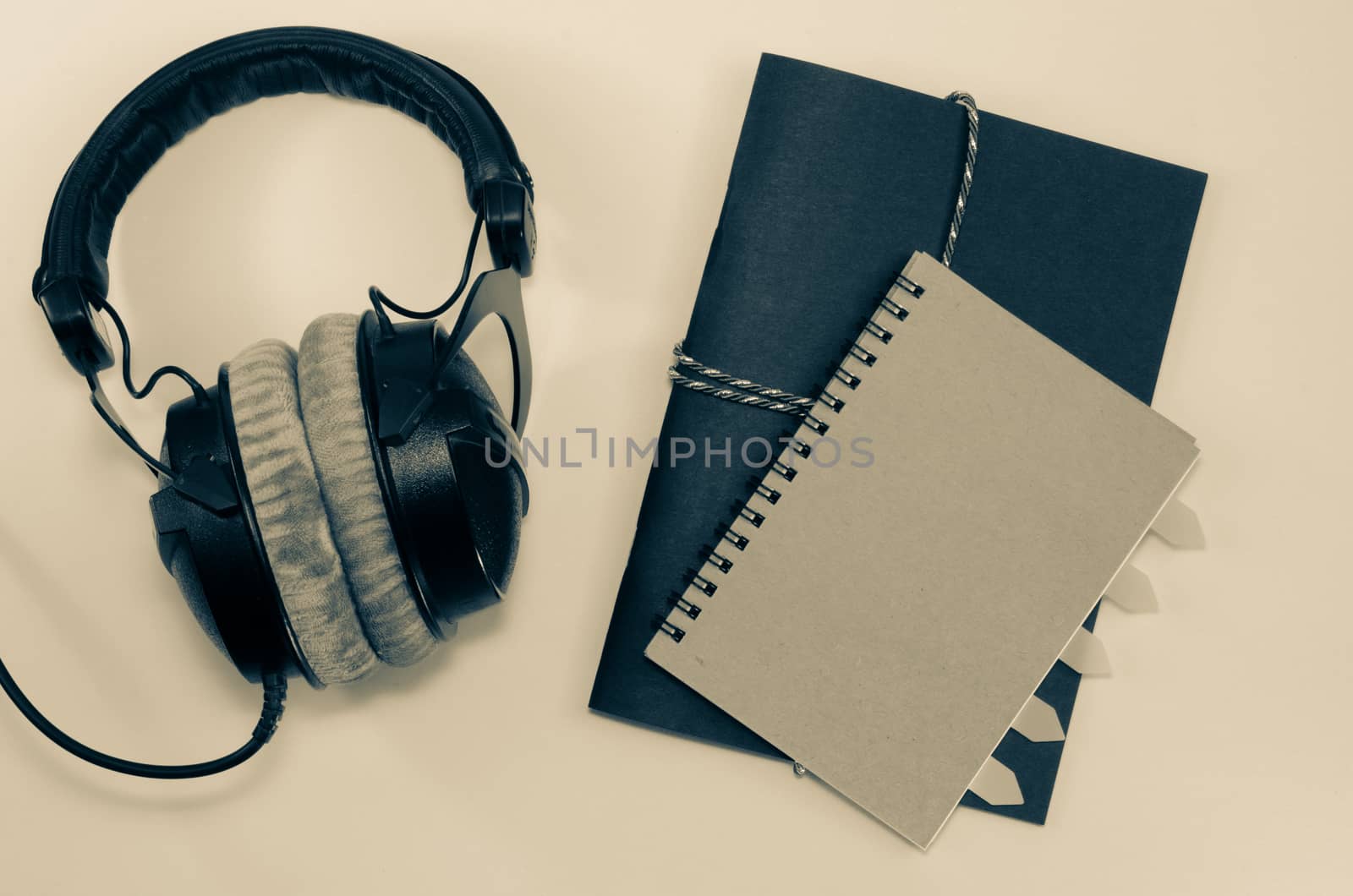 Headphone and notebook front cover on white background
