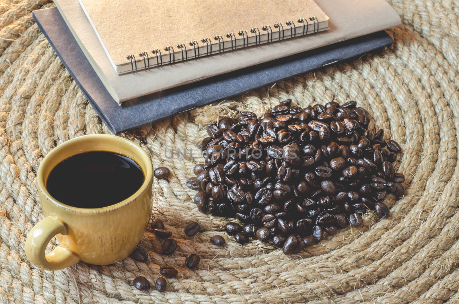 Cup of coffee with  notebook on a jute rope.