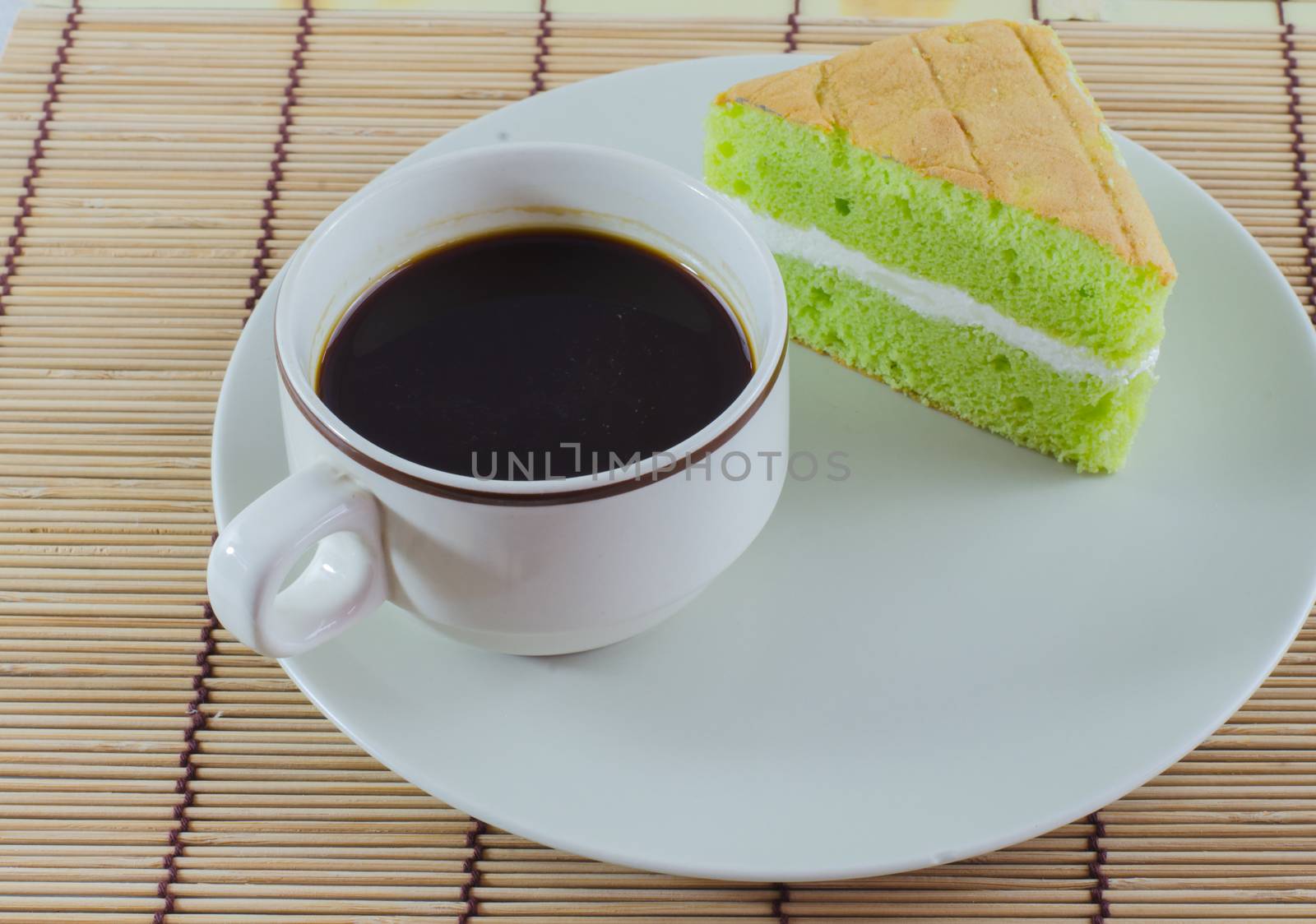 Coffee cup pandan sponge cake isolated on dish White background by metal22