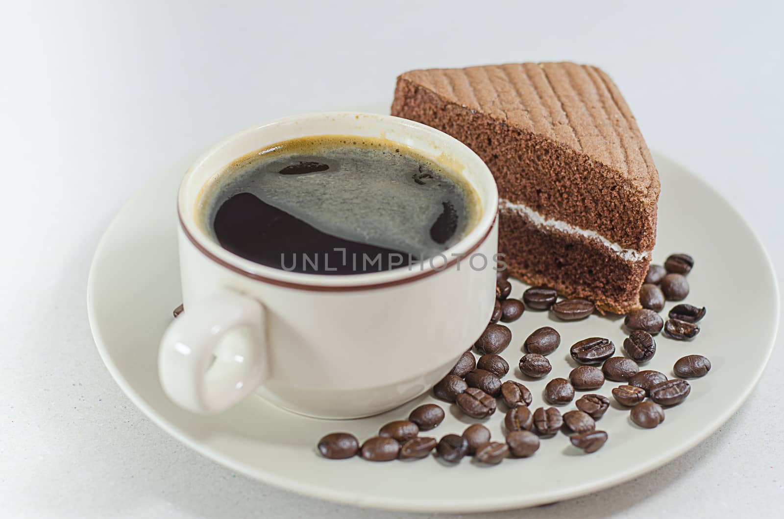 A cup of coffee with slice of chocolate cake on White background