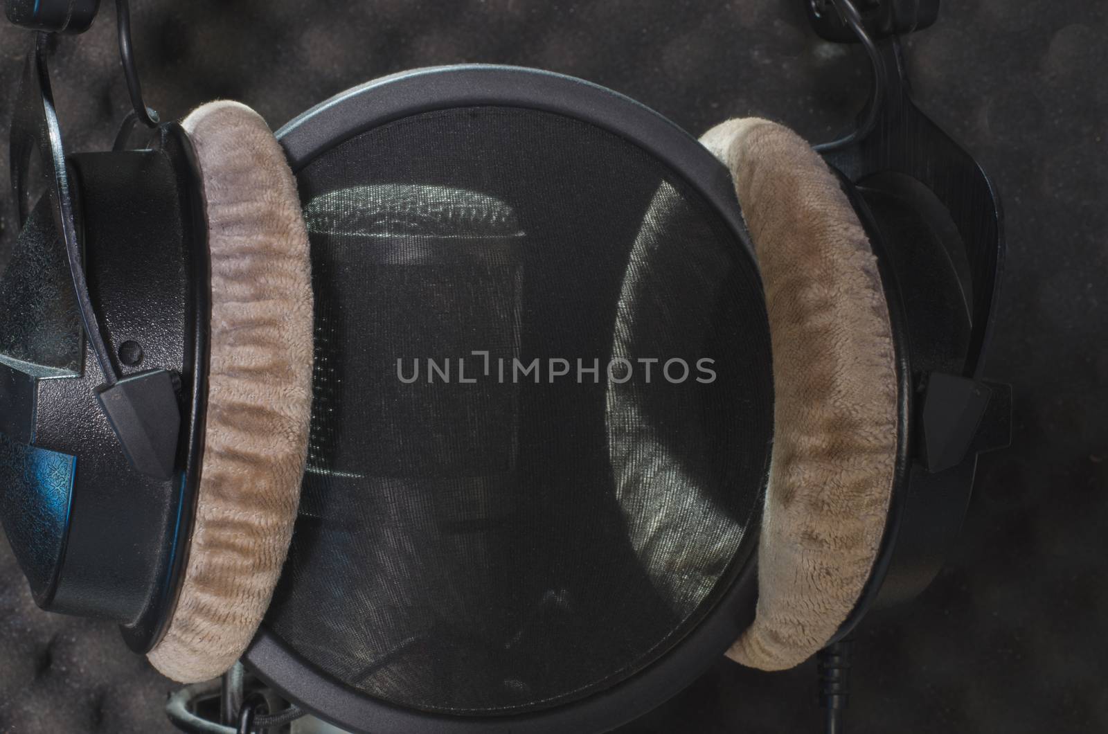 Headphone and microphone recording studio on a black background.