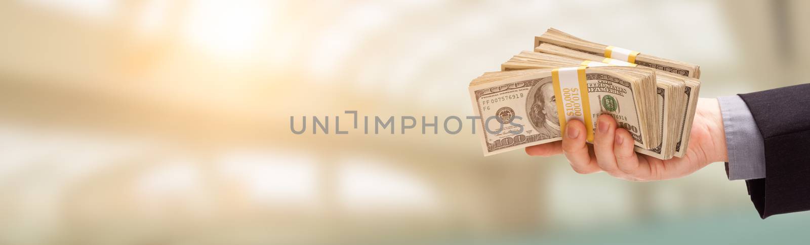 Male Hand Holding Stack of Cash Wide Banner With Room For Copy. by Feverpitched
