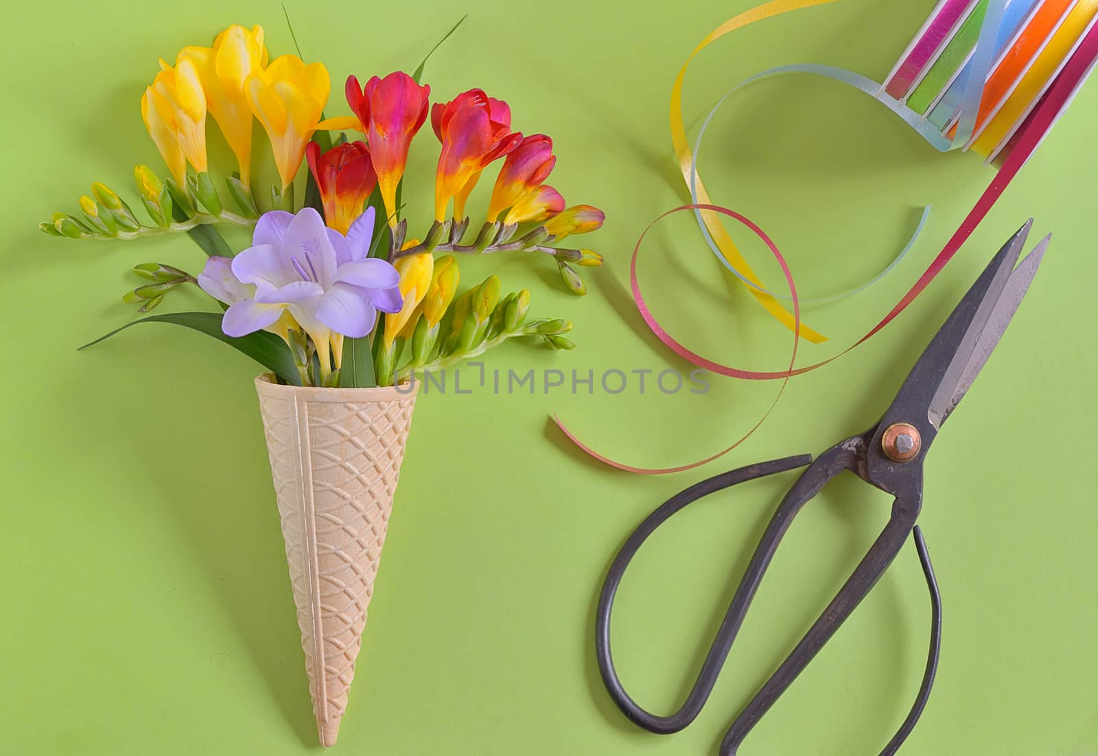 Freesias flowers in ice cream waffles and vintage scissors