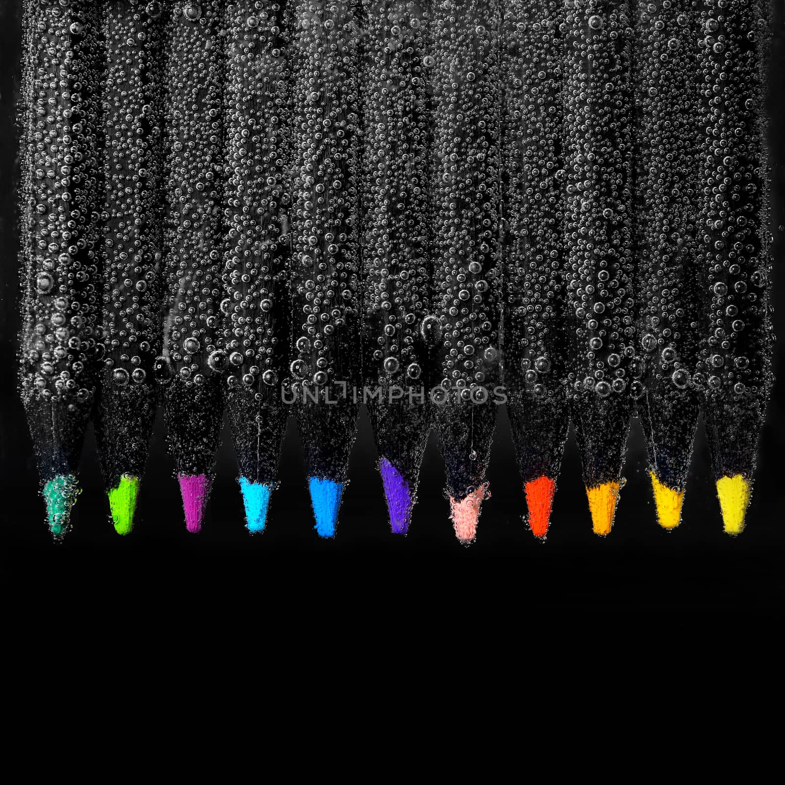 Set of colored pencils and bubbles on black background