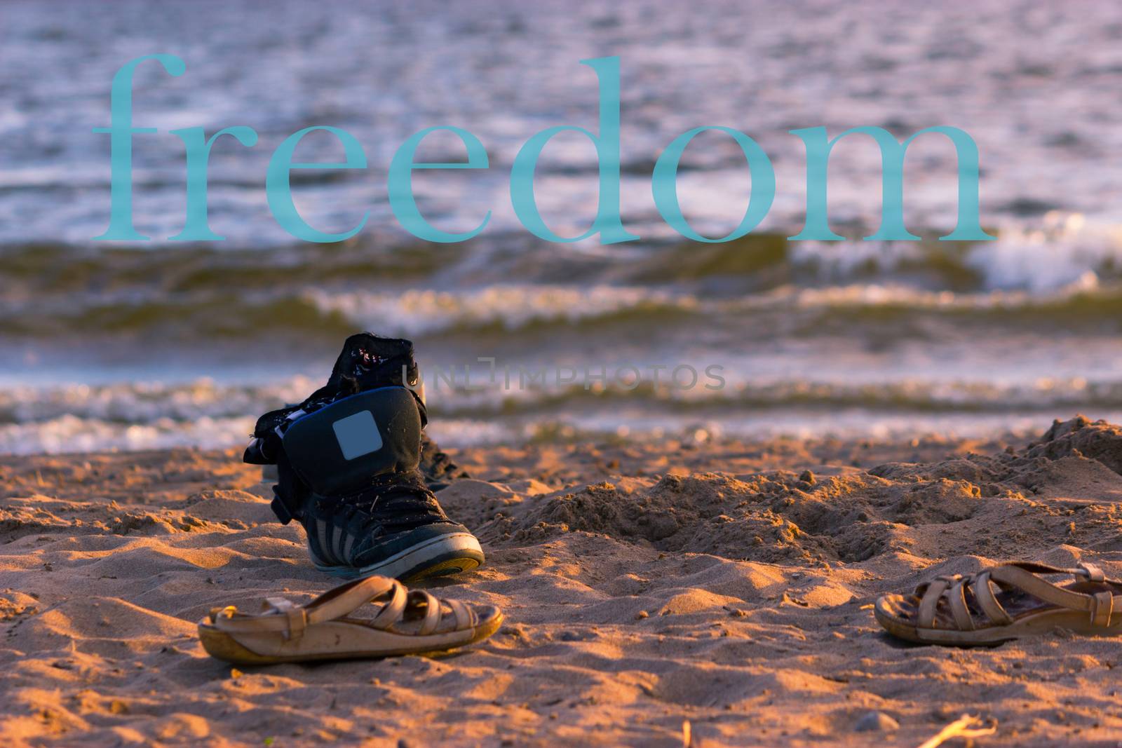 sneakers with sea wave on sand background. freedom word