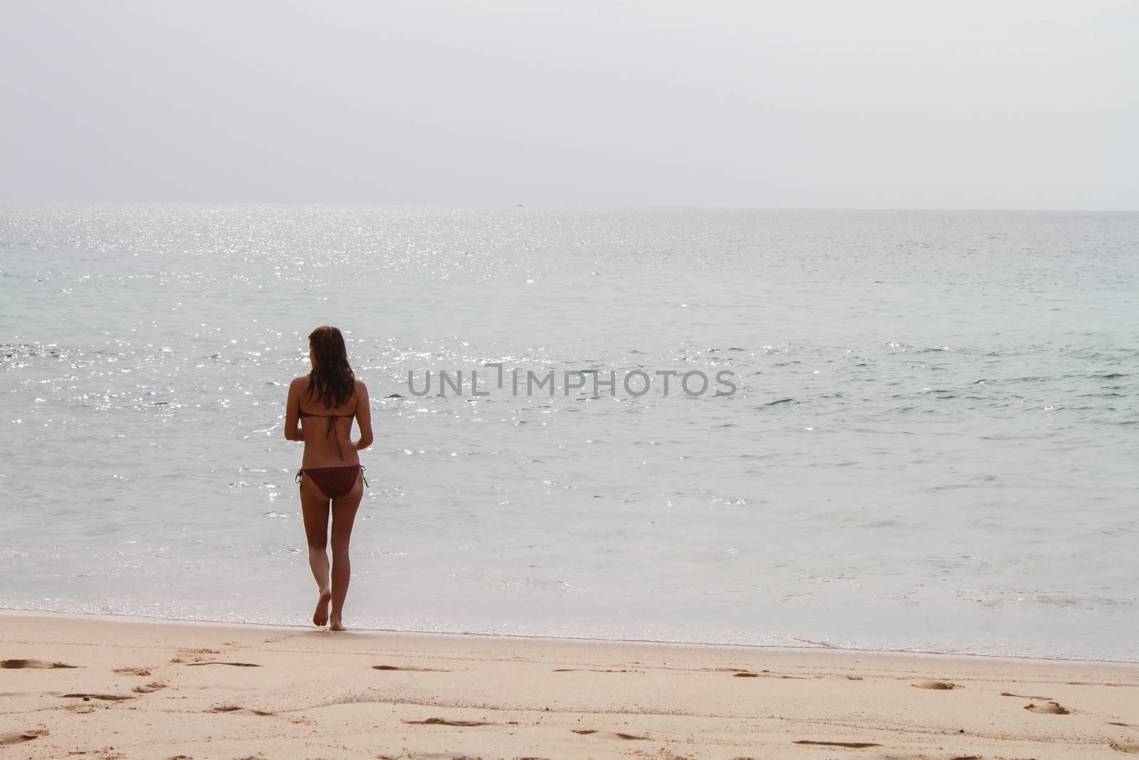 womman walking through the beach. Vacations on shore by evolutionnow