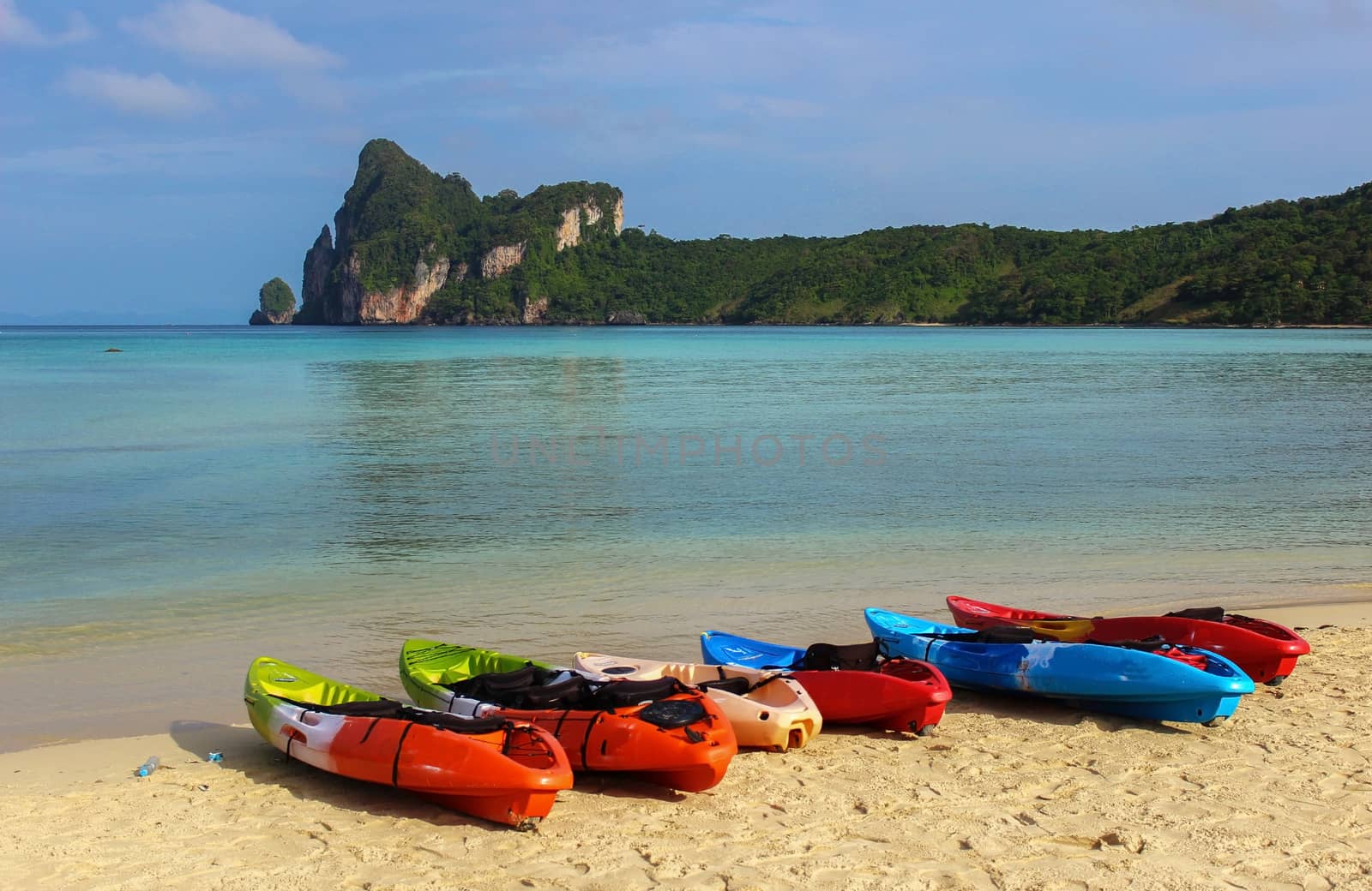 Kayaks canoe boats on the beach during sunny day by evolutionnow