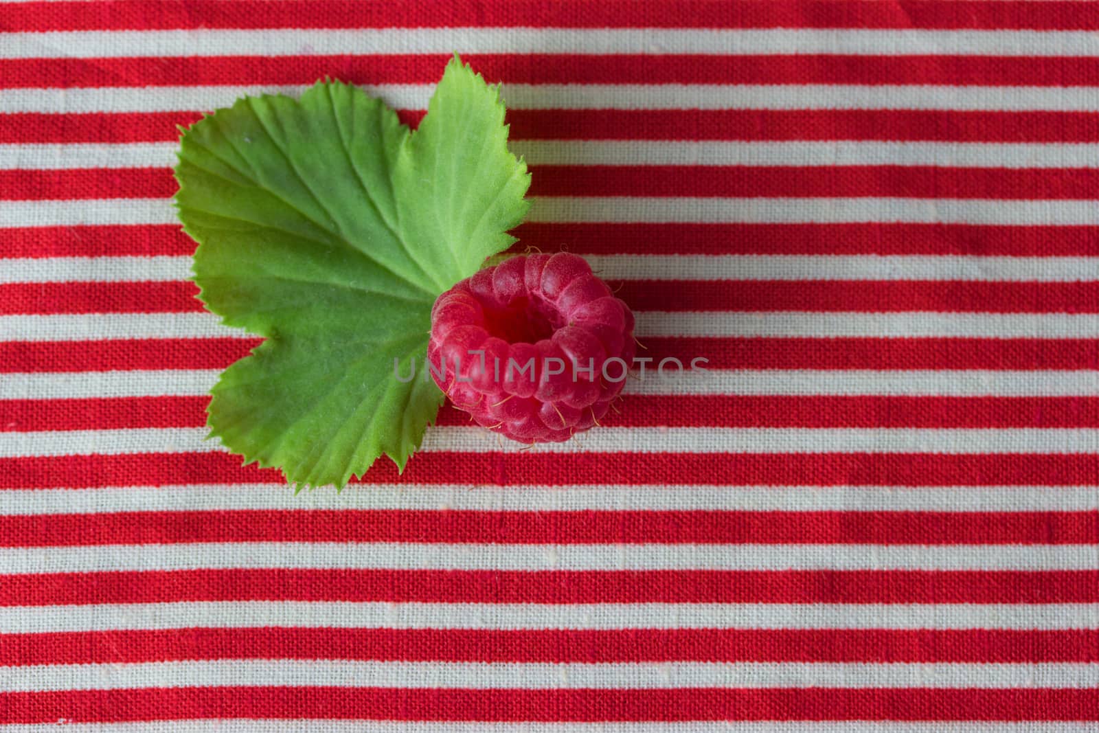 raspberry on stripted red cloth. copy space