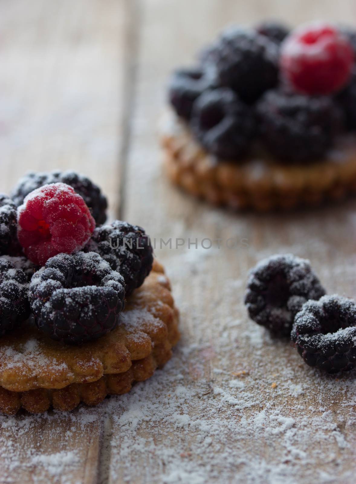 Fresh berry tartlet or cake filled with raspberry blackberry icing