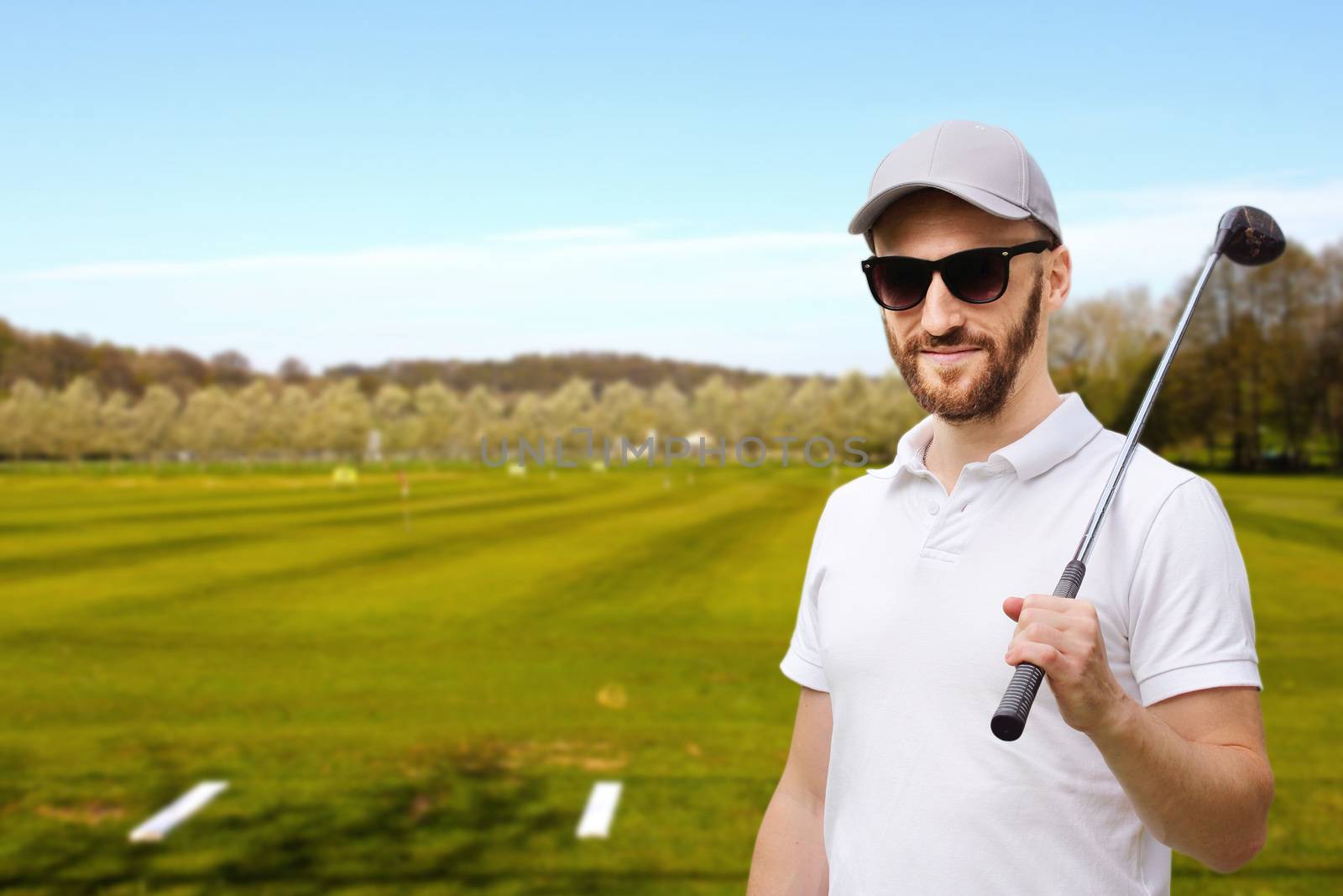 Golfer man posing with golf club at golf course