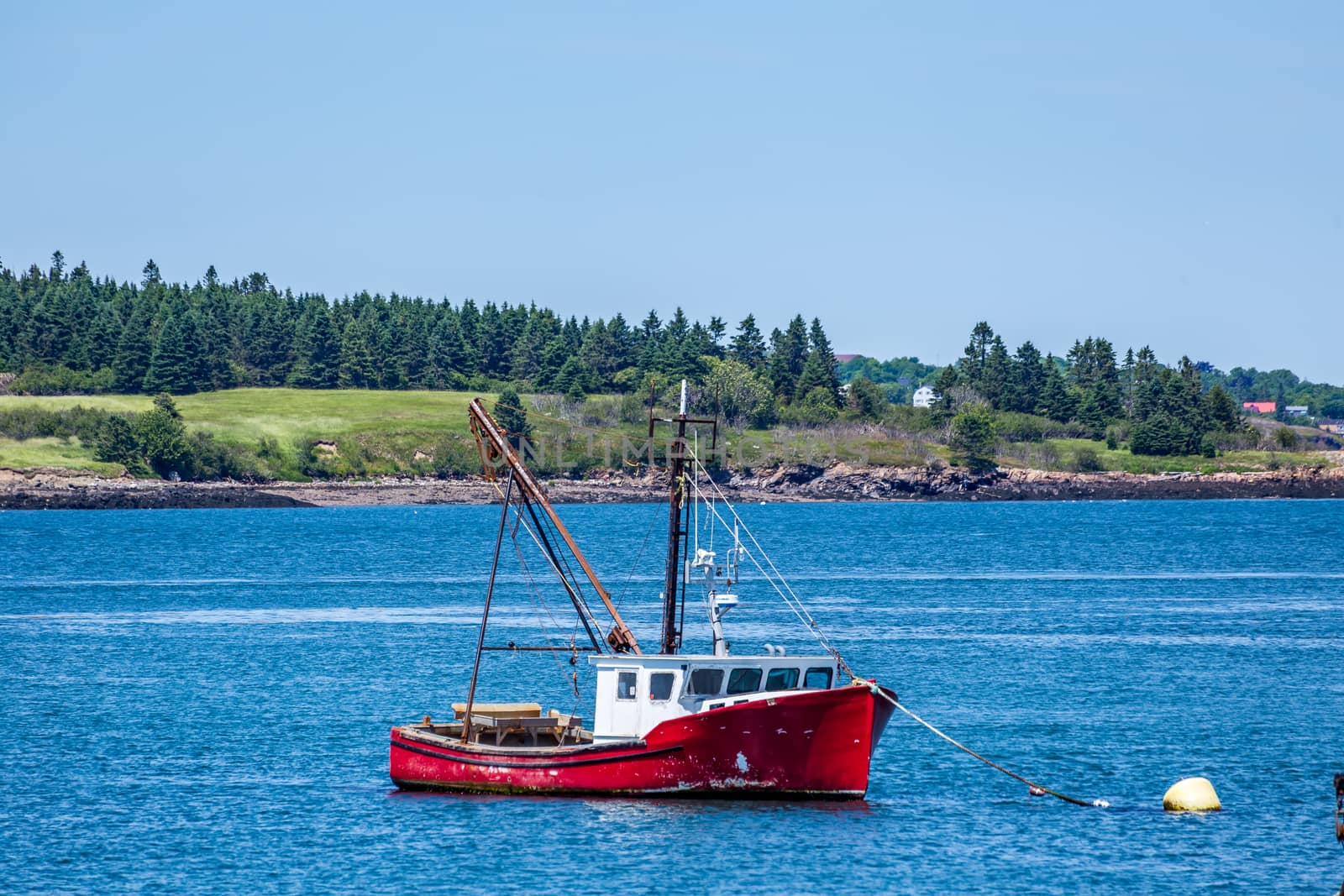 A hard working lobster boat lays at anchor in a small harbor in the Down East region of Maine.
