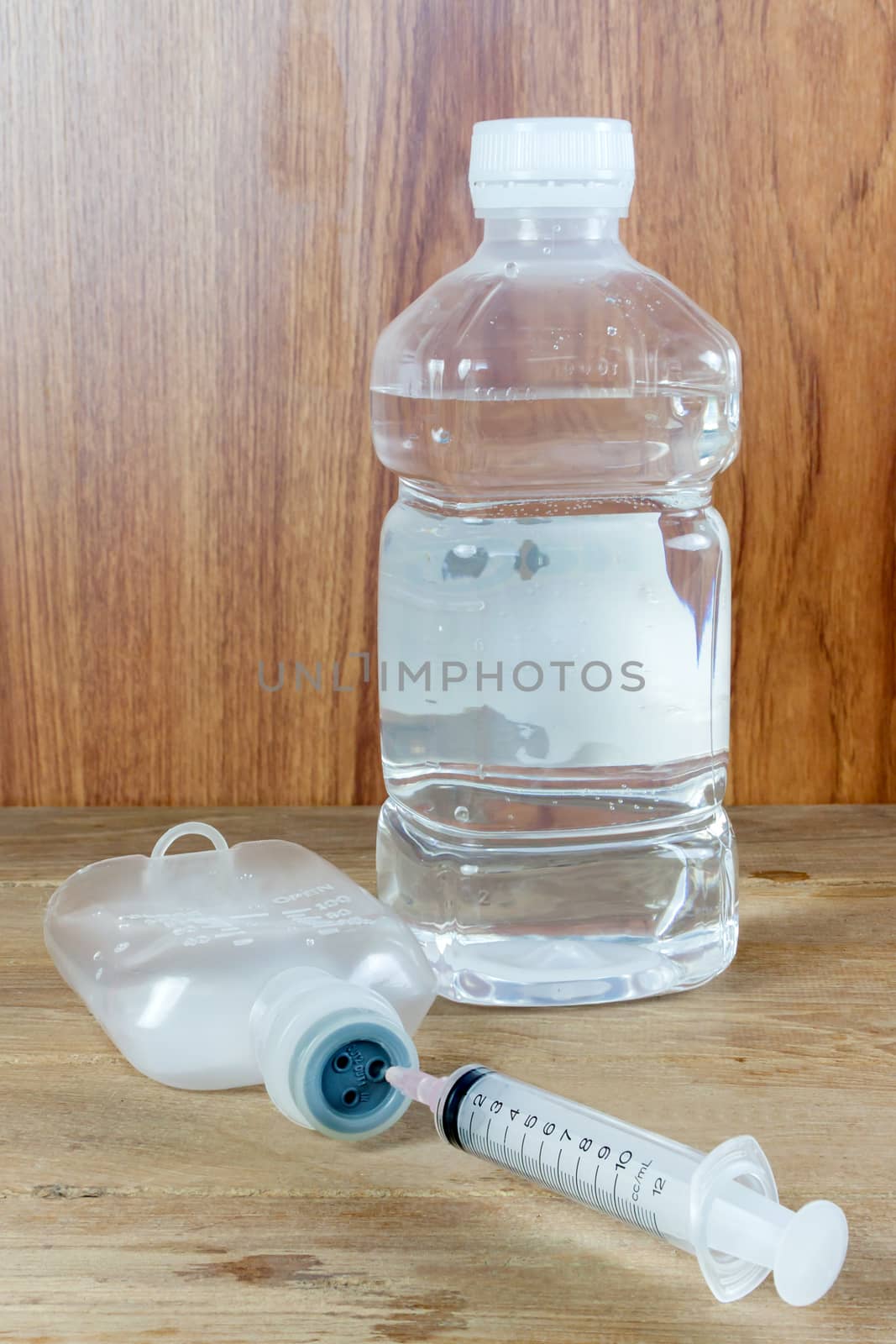 saline solution and injection needle on wood table