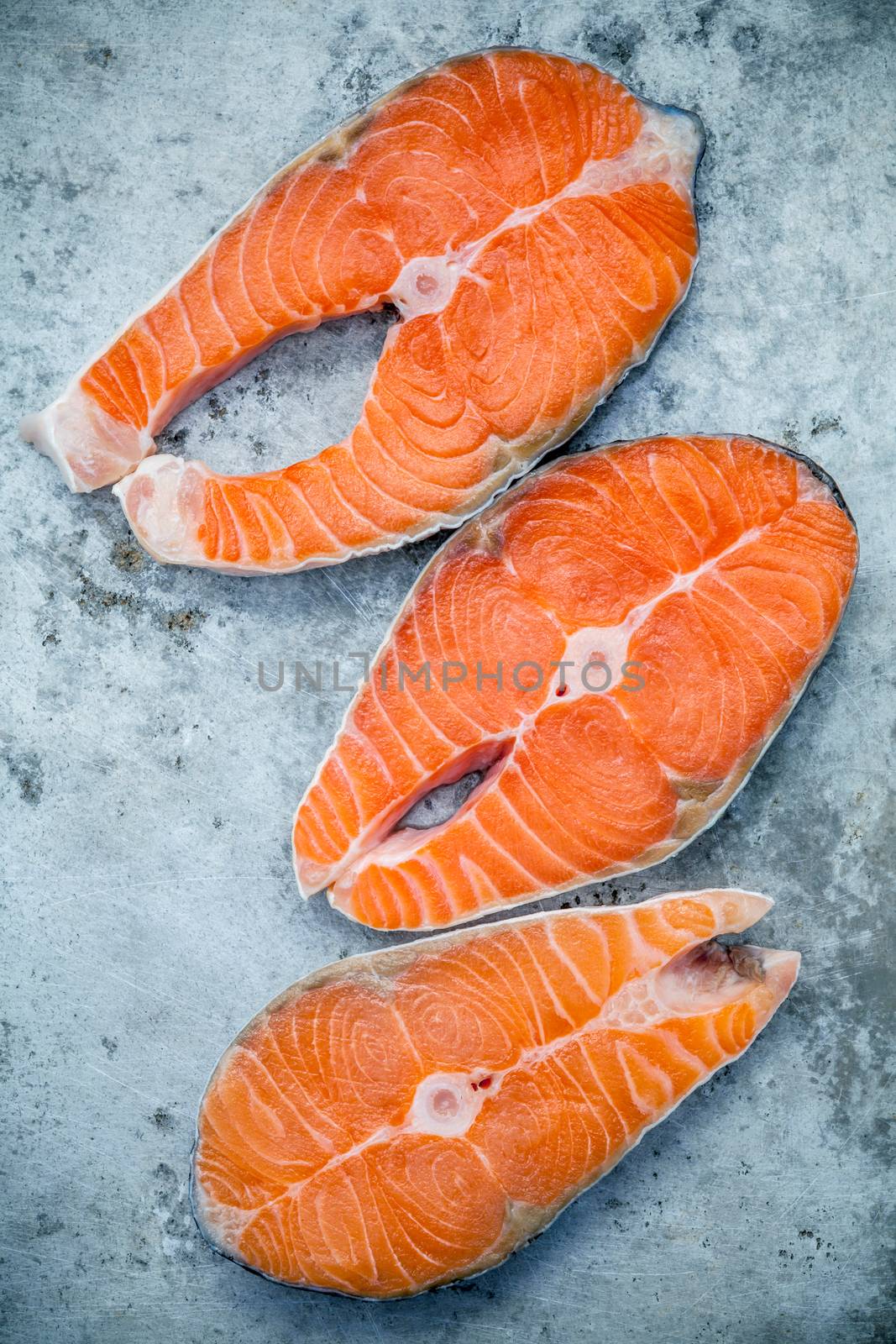Fresh salmon fillet sliced flat lay on shabby metal background.  by kerdkanno